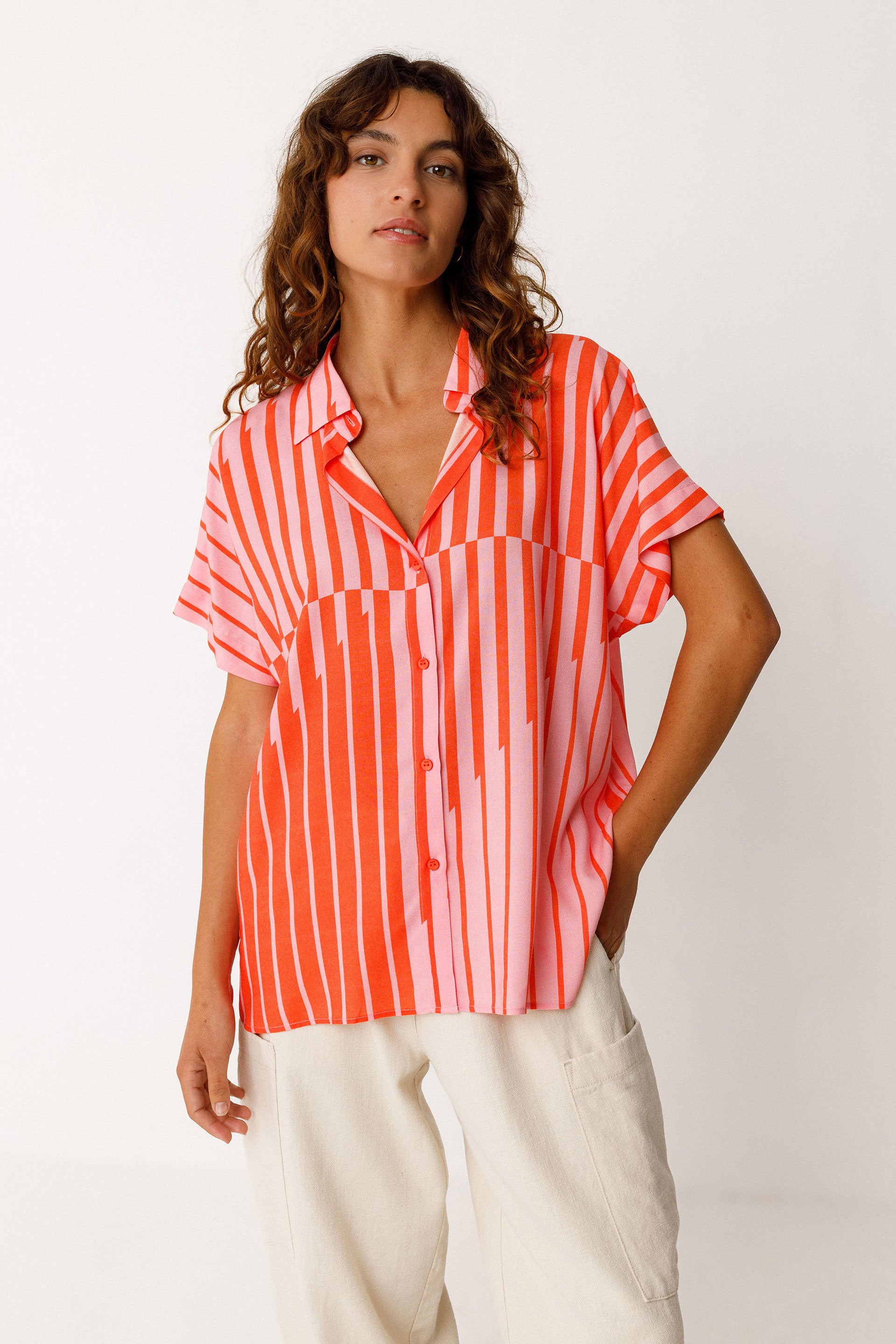 Woman wearing a red and pink striped shirt on a white background