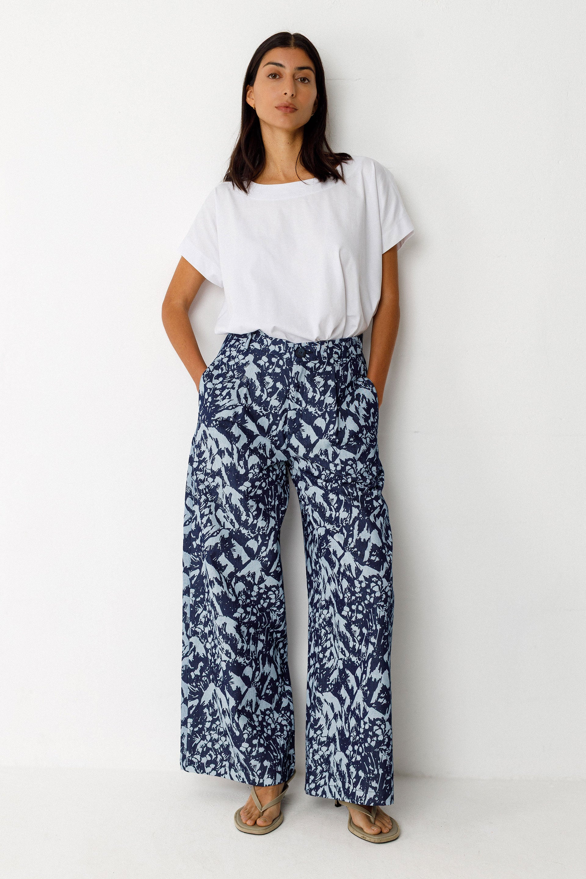 Woman wearing a white t-shirt and blue floral pants on a white background