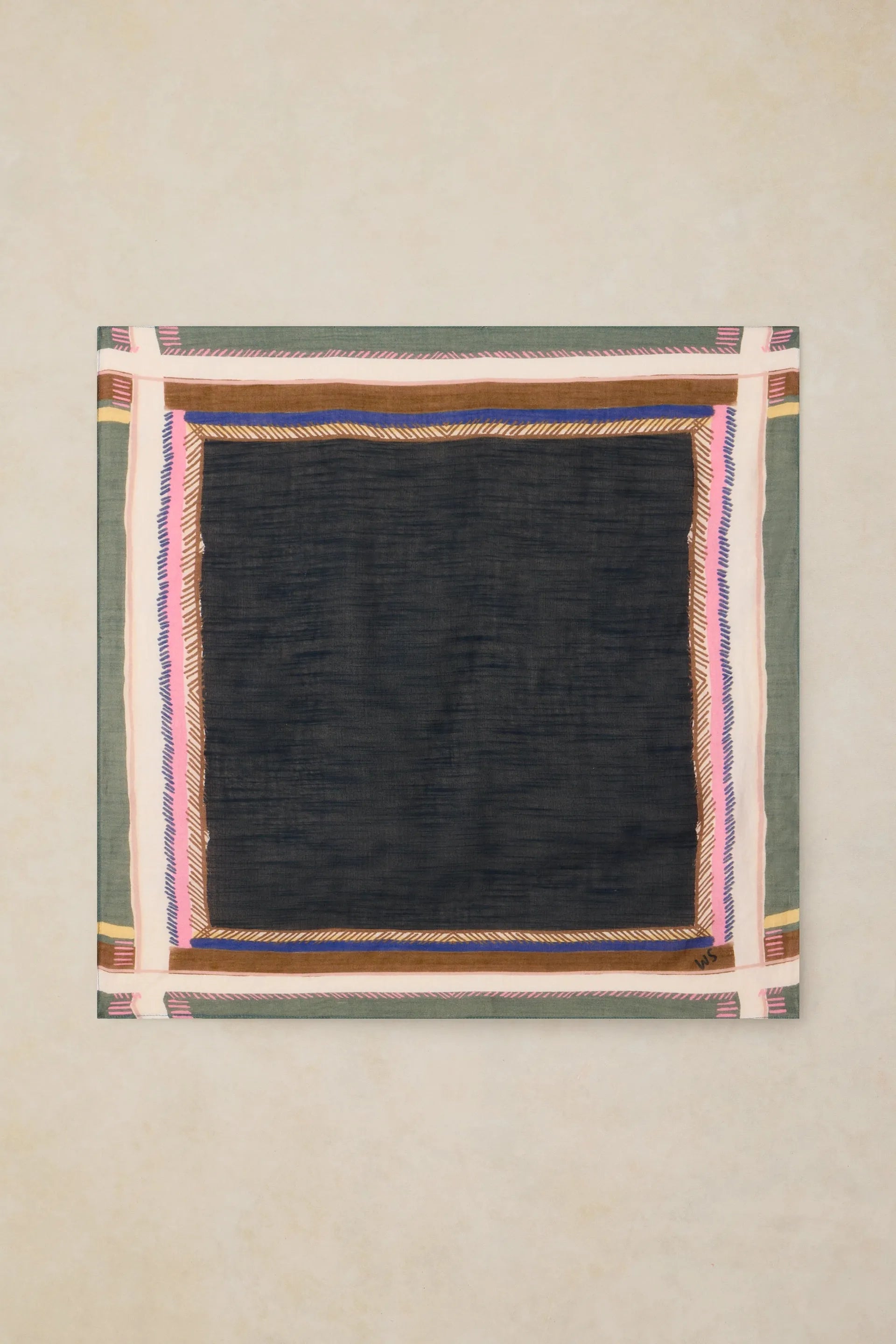 A square textile piece with a large black center and a multicolored geometric border, displayed flat against a light beige textured background.