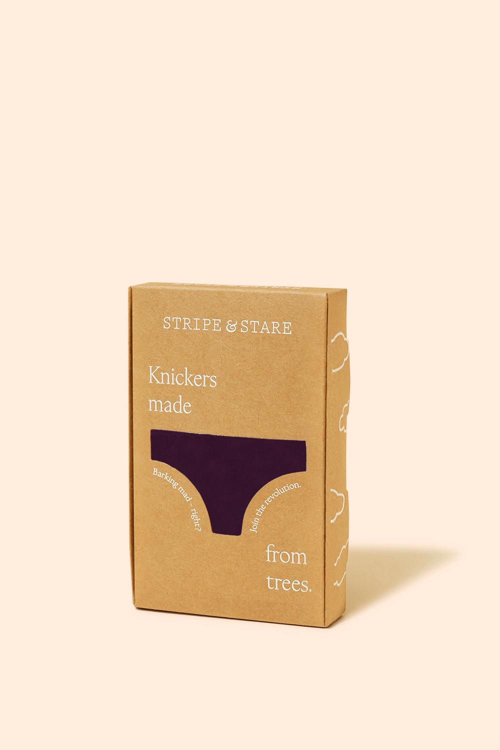 Stripe and Stare branded cardboard gift box containing luxury women's underwear on a light pink background.