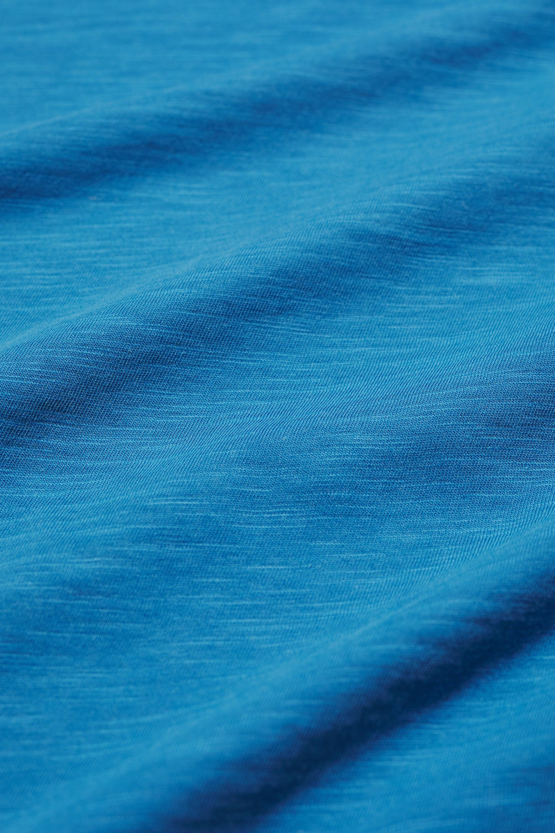 Close-up of blue organic cotton fabric with visible texture