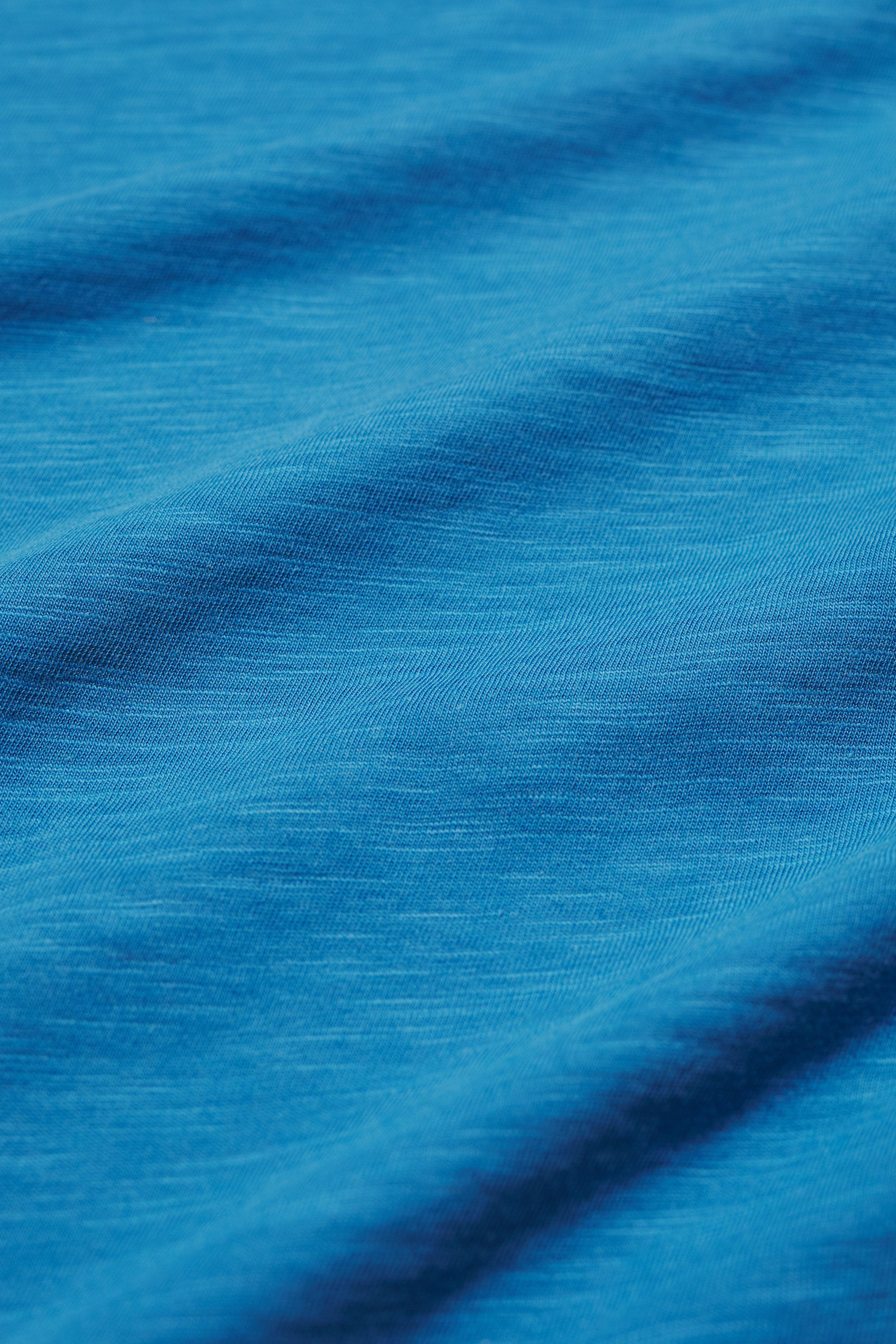 Close-up of blue organic cotton fabric with visible texture