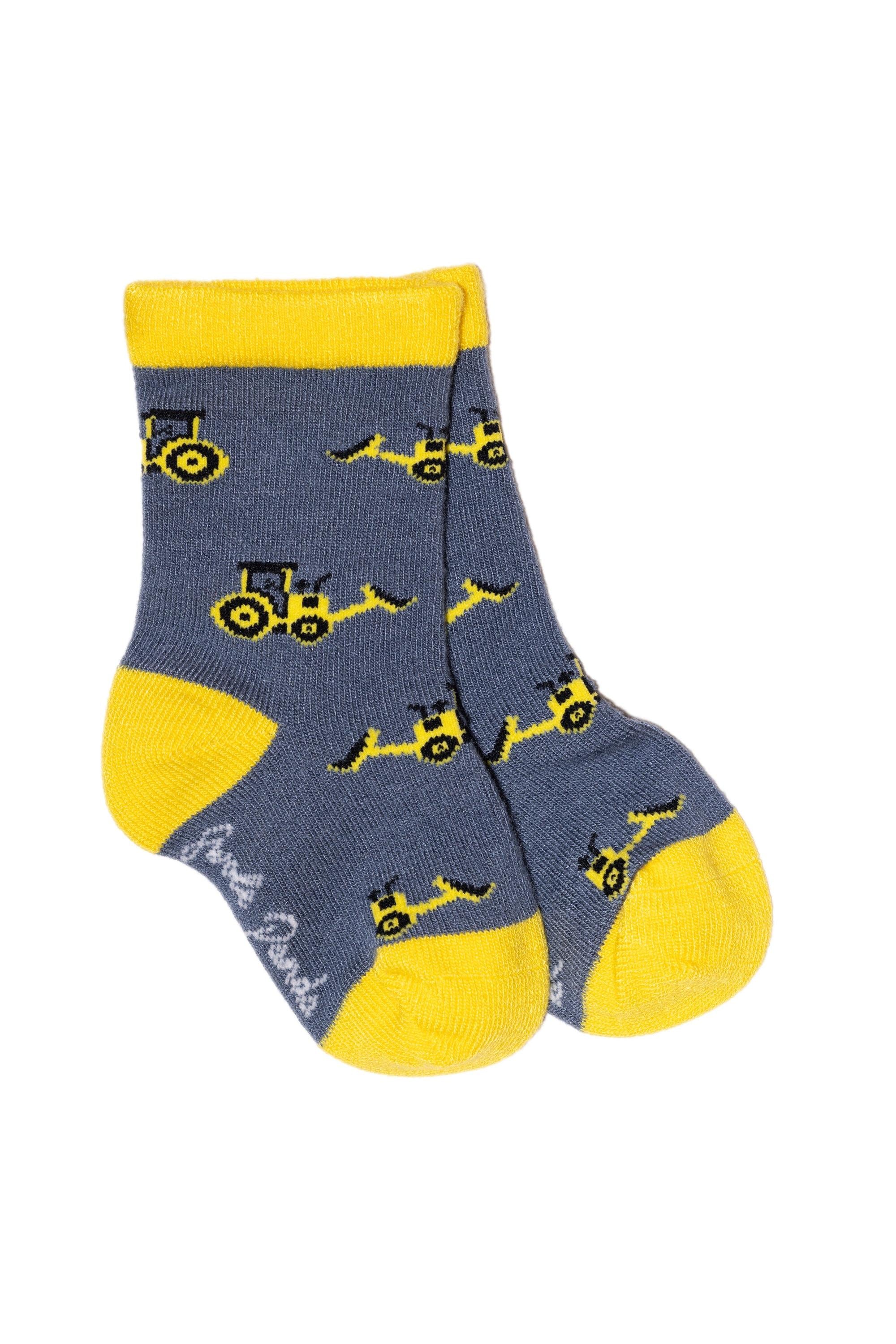 A pair of grey bamboo socks by Swole Panda featuring a yellow tractor pattern.