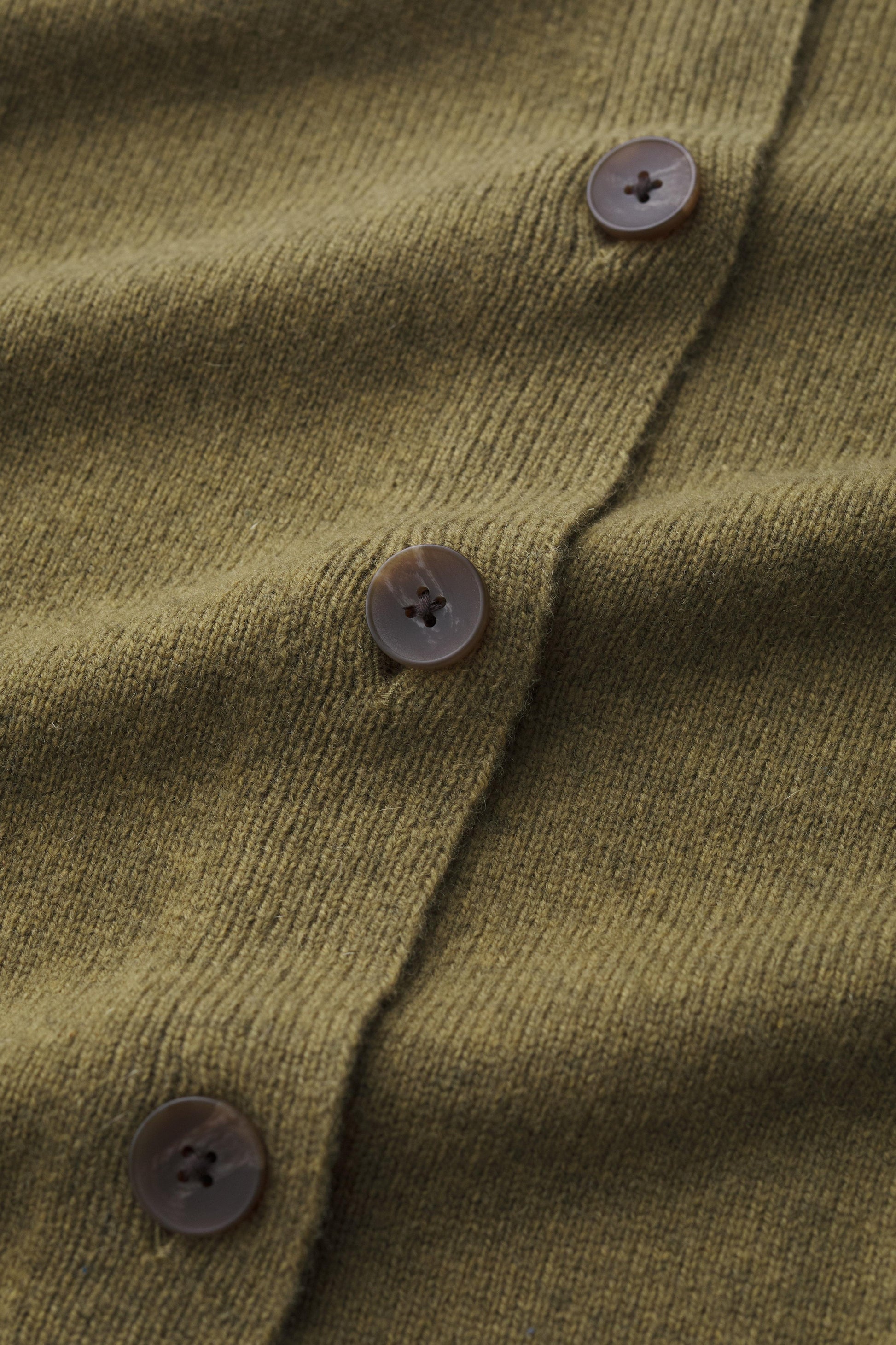 Close-up of a green textured fabric with buttons