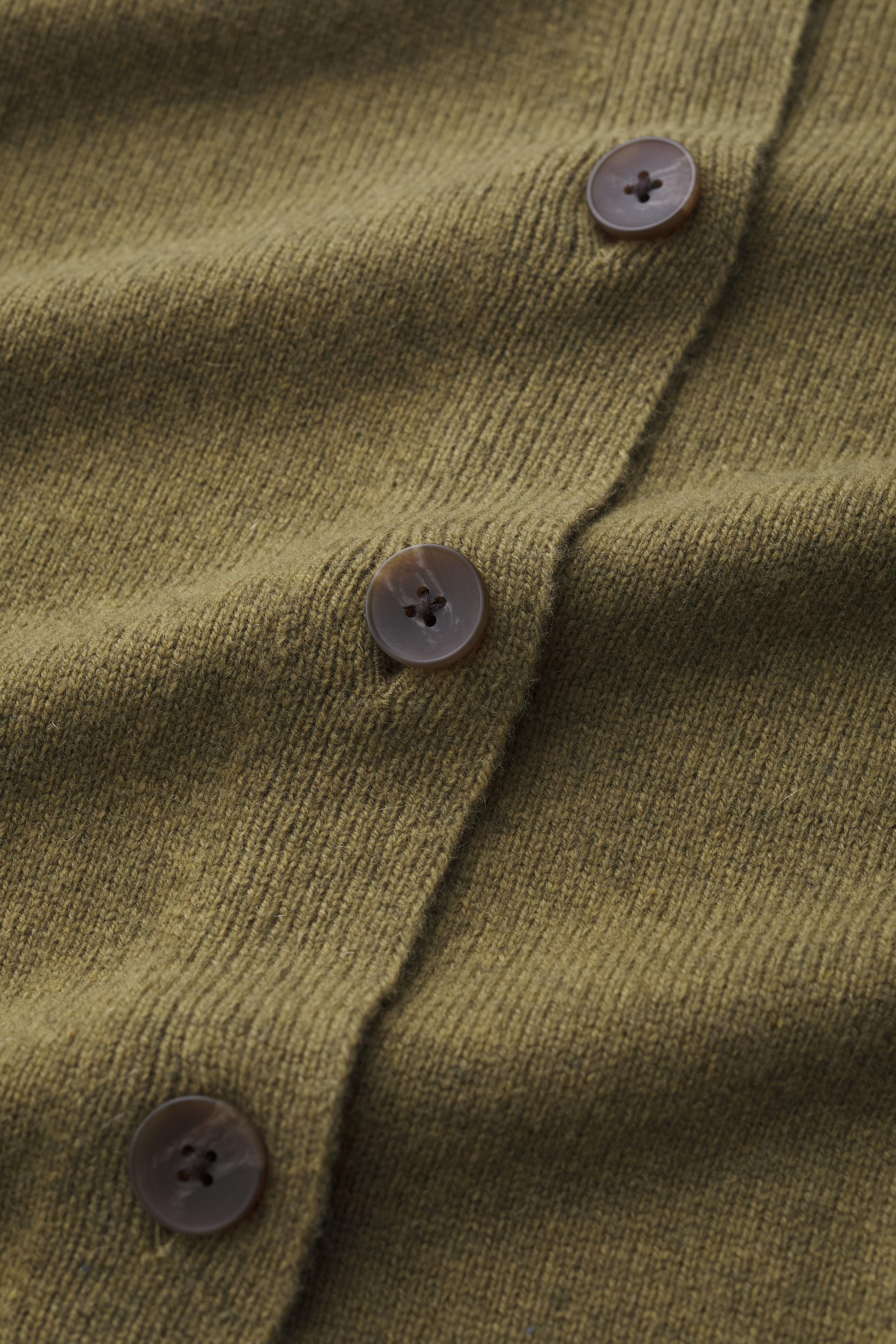 Close-up of a green textured fabric with buttons