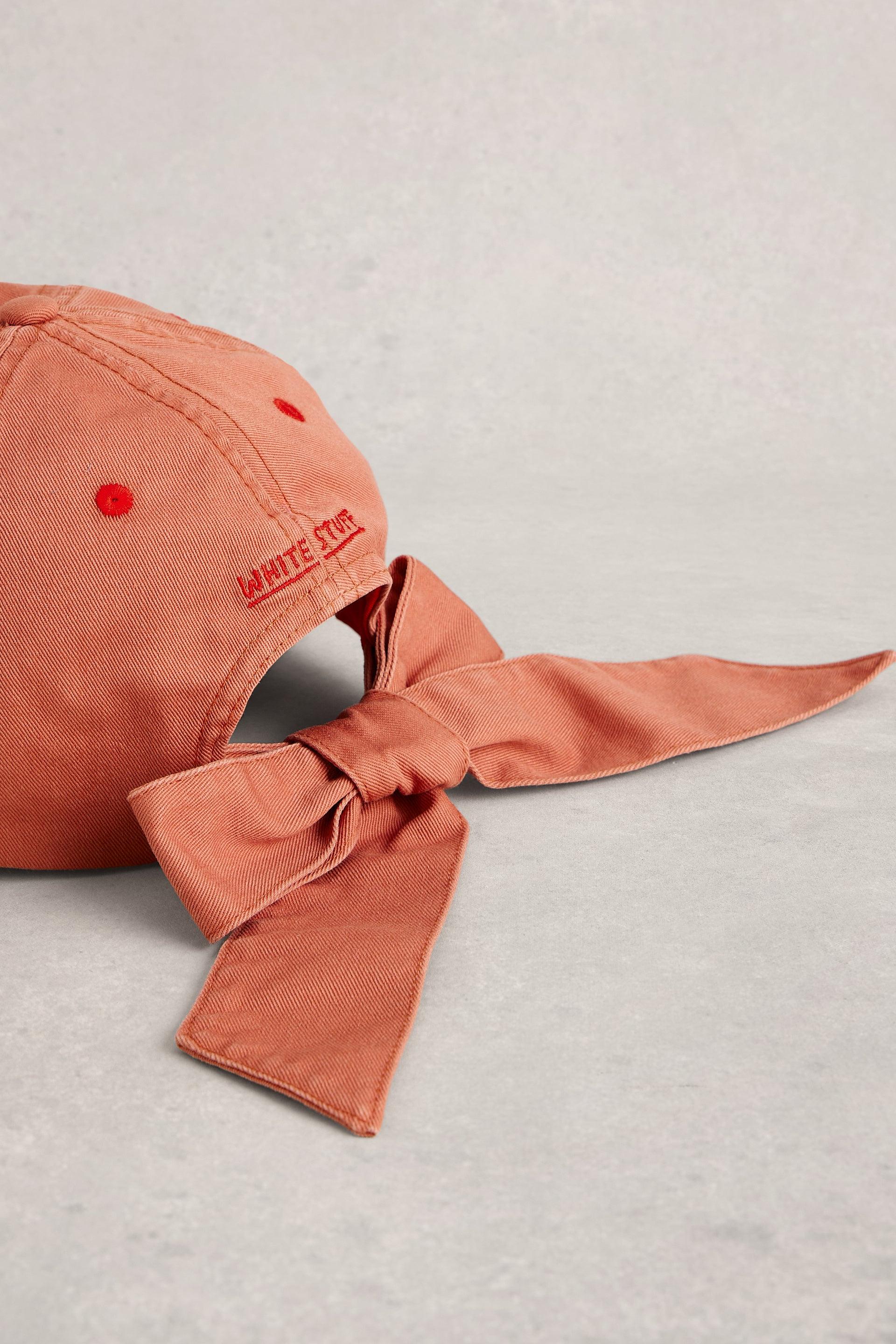 Orange baseball cap with bow detail and White Stuff branding