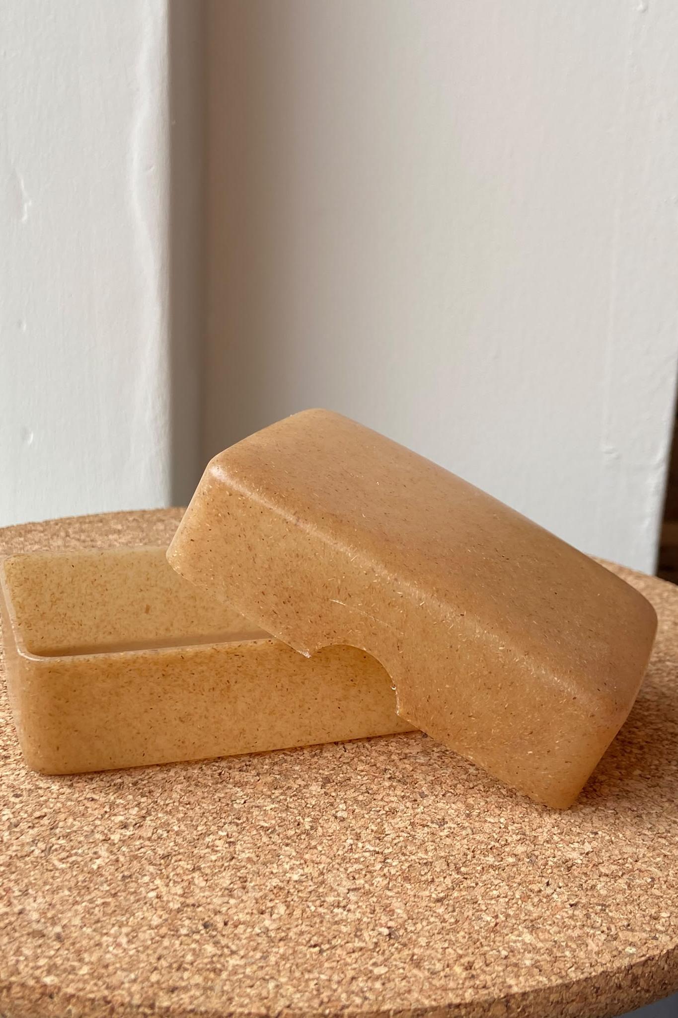 An open soap case on a cork surface