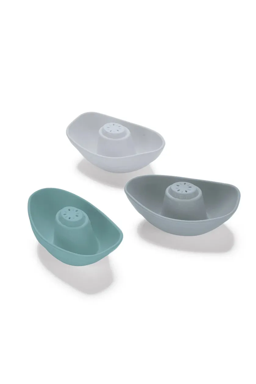 Three boat-shaped silicone sieves in different colors on a white background