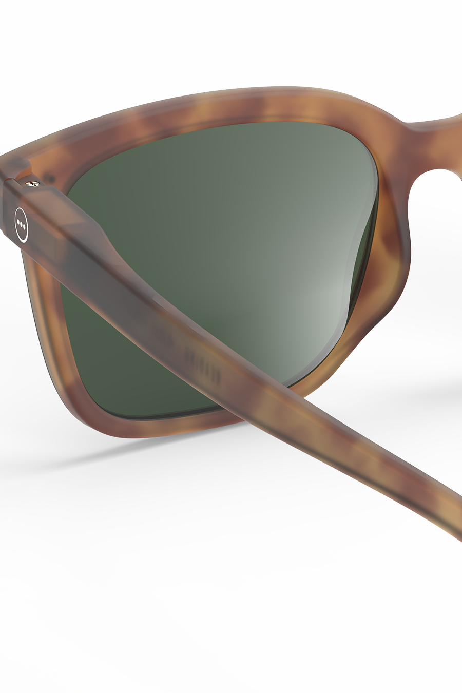 Close-up of brown tortoiseshell Izipizi sunglasses with green lenses.