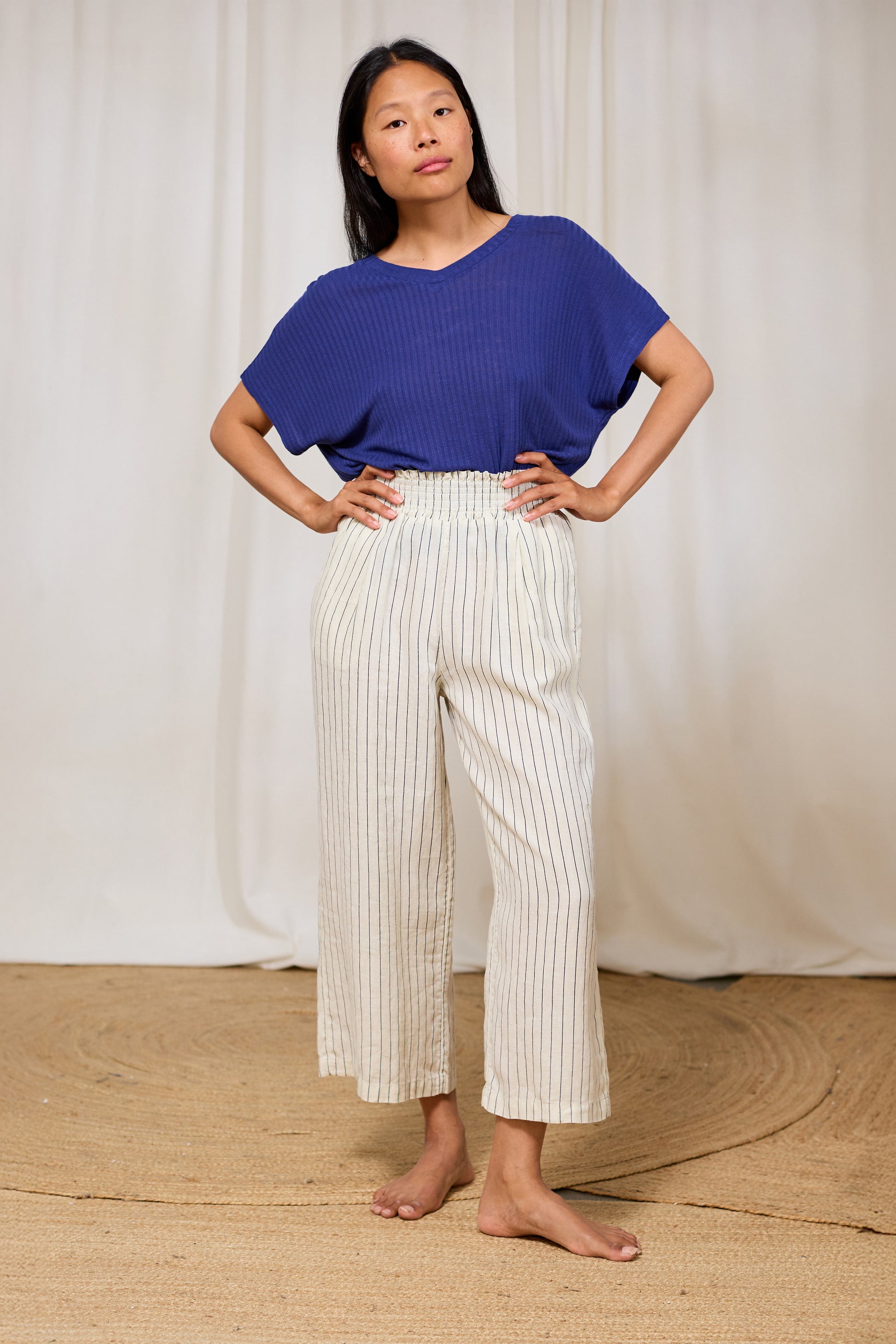 Model wearing a navy ribbed V-neck top in TENCEL™ Lyocell and linen.