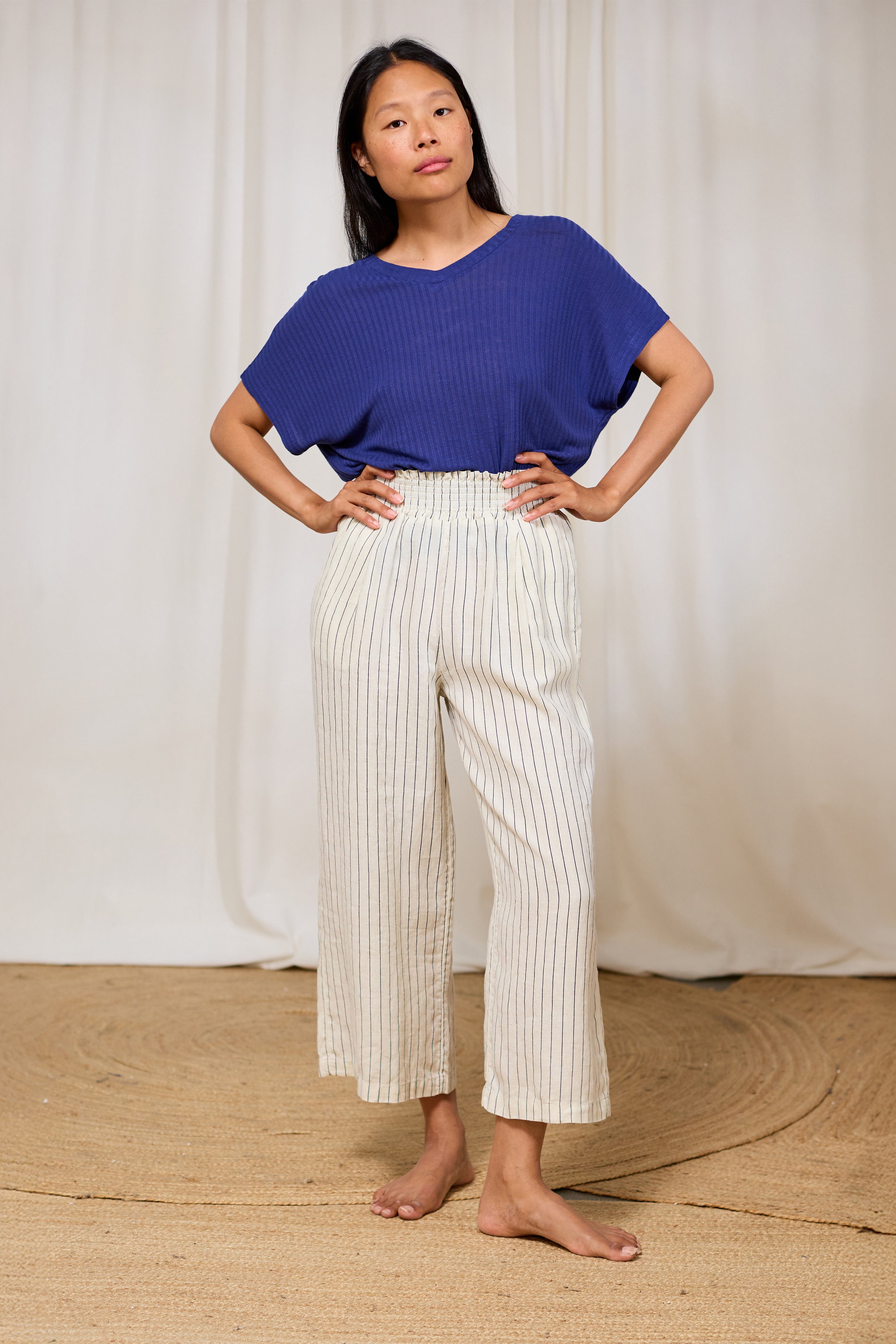 Model wearing a navy ribbed V-neck top in TENCEL™ Lyocell and linen.