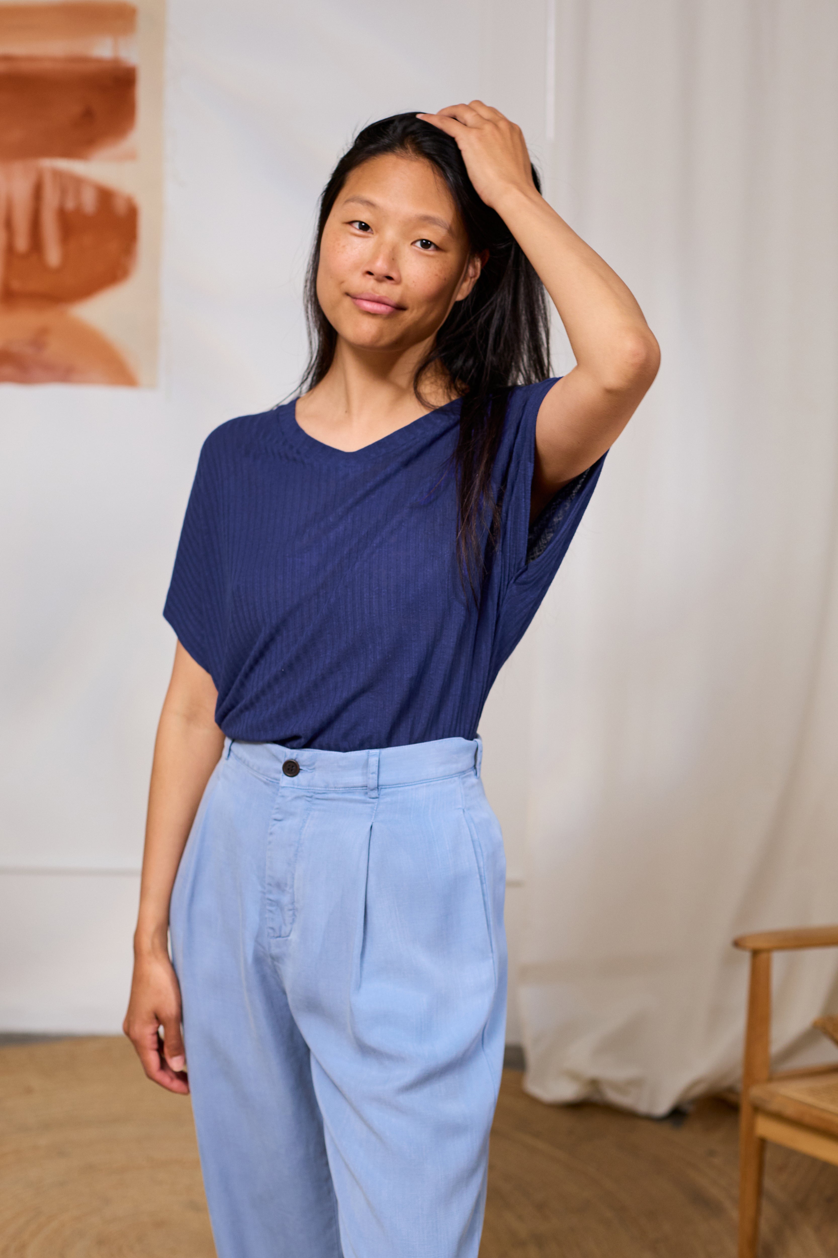 Model wearing a twothirds navy tencel linen v neck top.