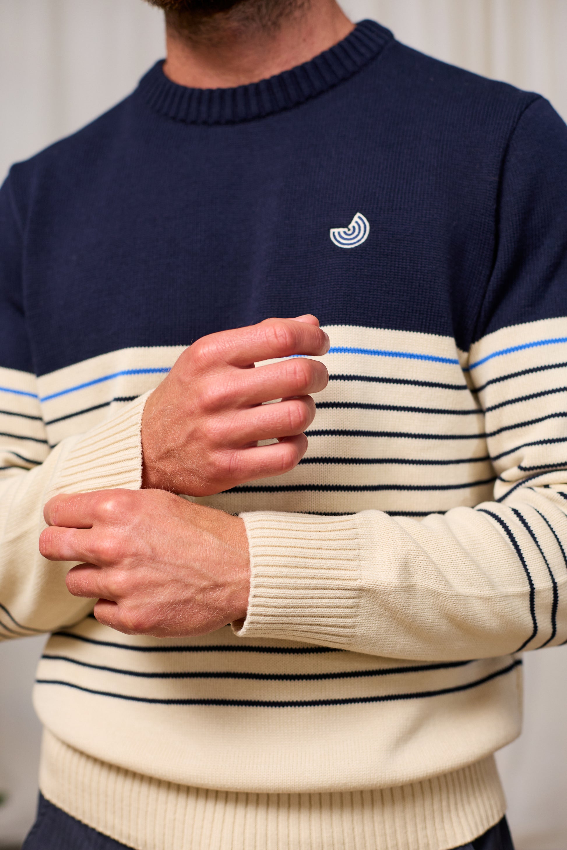 Person wearing a navy and cream striped sweater with TWOTHIRDS logo on a plain background