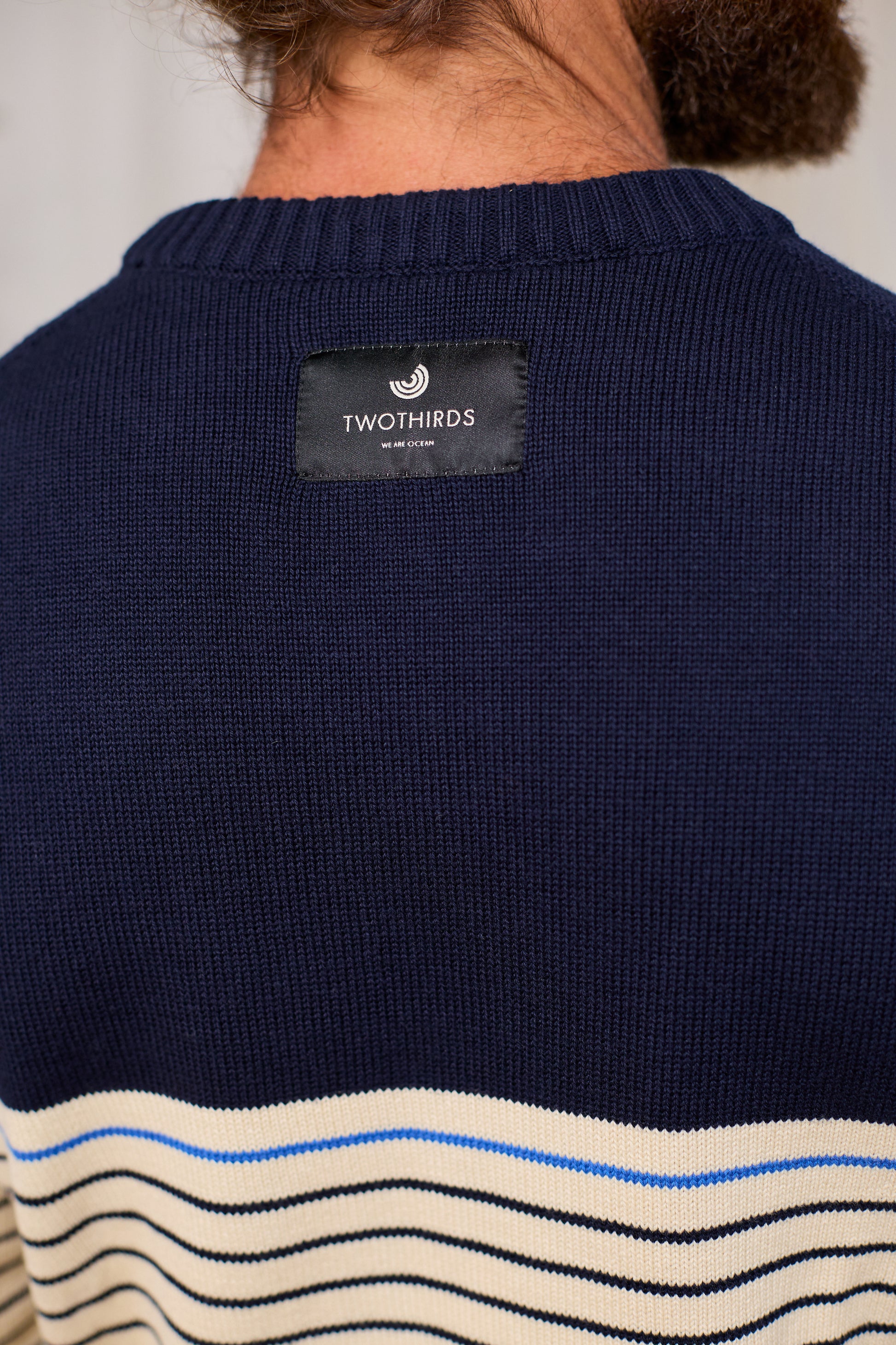Navy organic cotton sweater with TWOTHIRDS  label on the back, featuring a wavy pattern at the bottom.