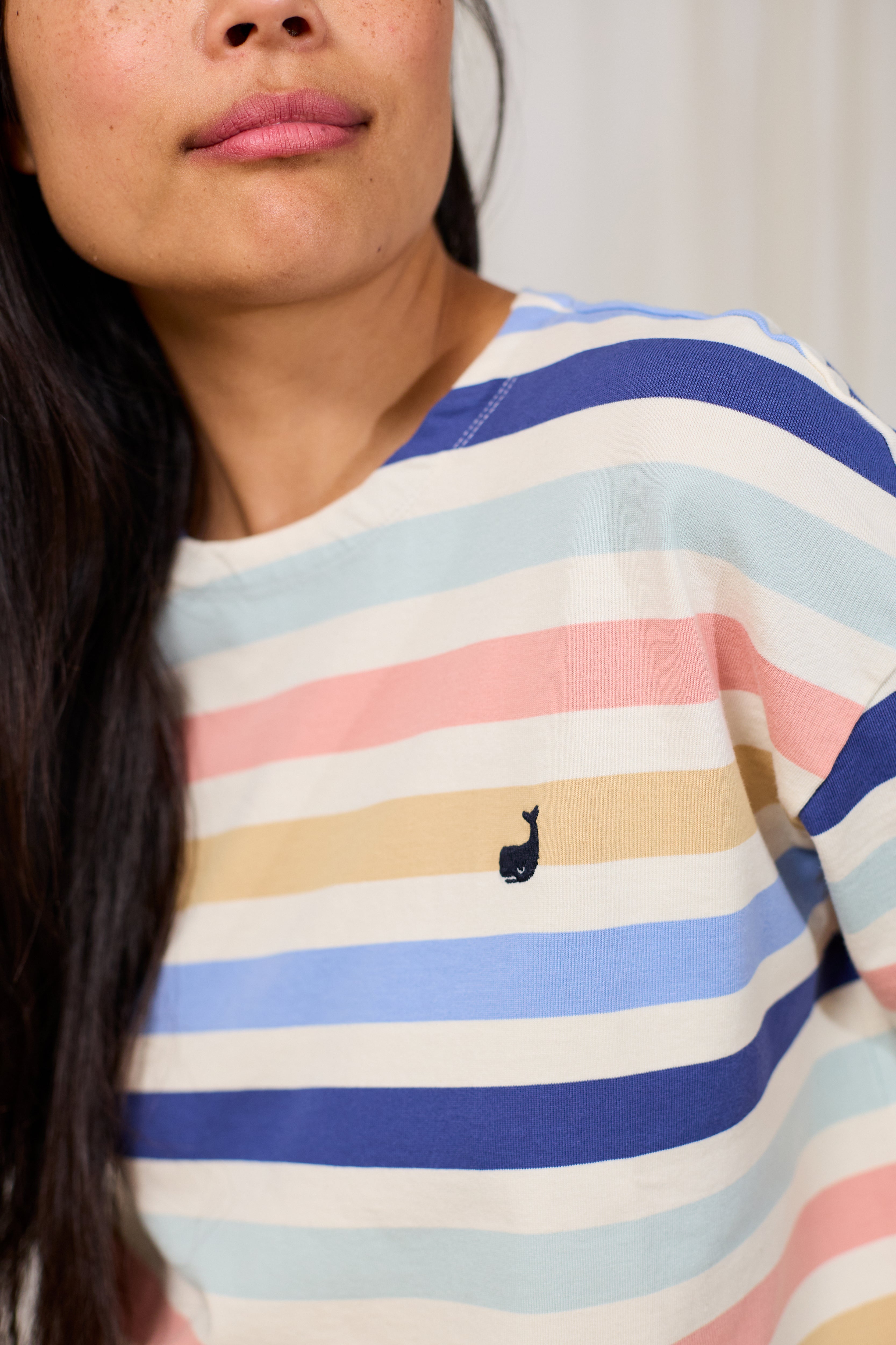 Person wearing a colourful striped shirt with TWOTHIRDS logo on a plain background