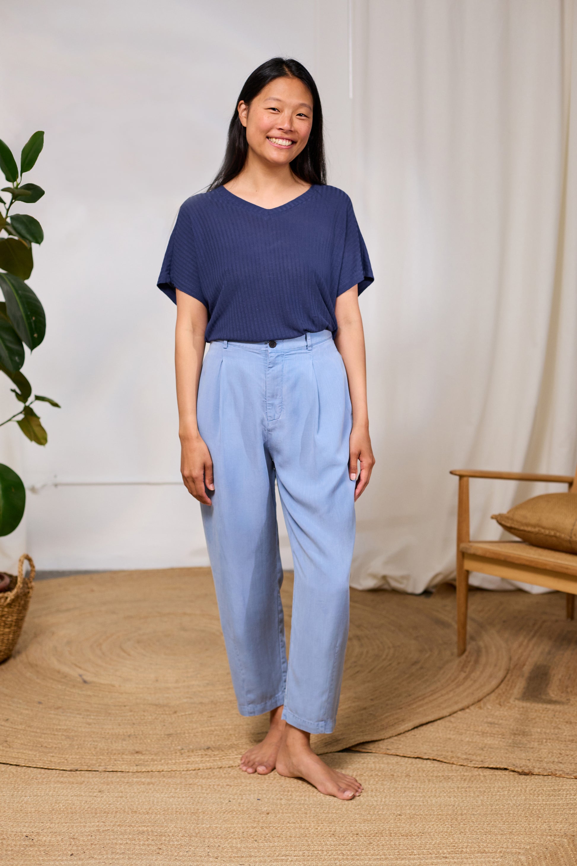 Model wearing a TWOTHIRDS organic cotton top paired with blue trousers.