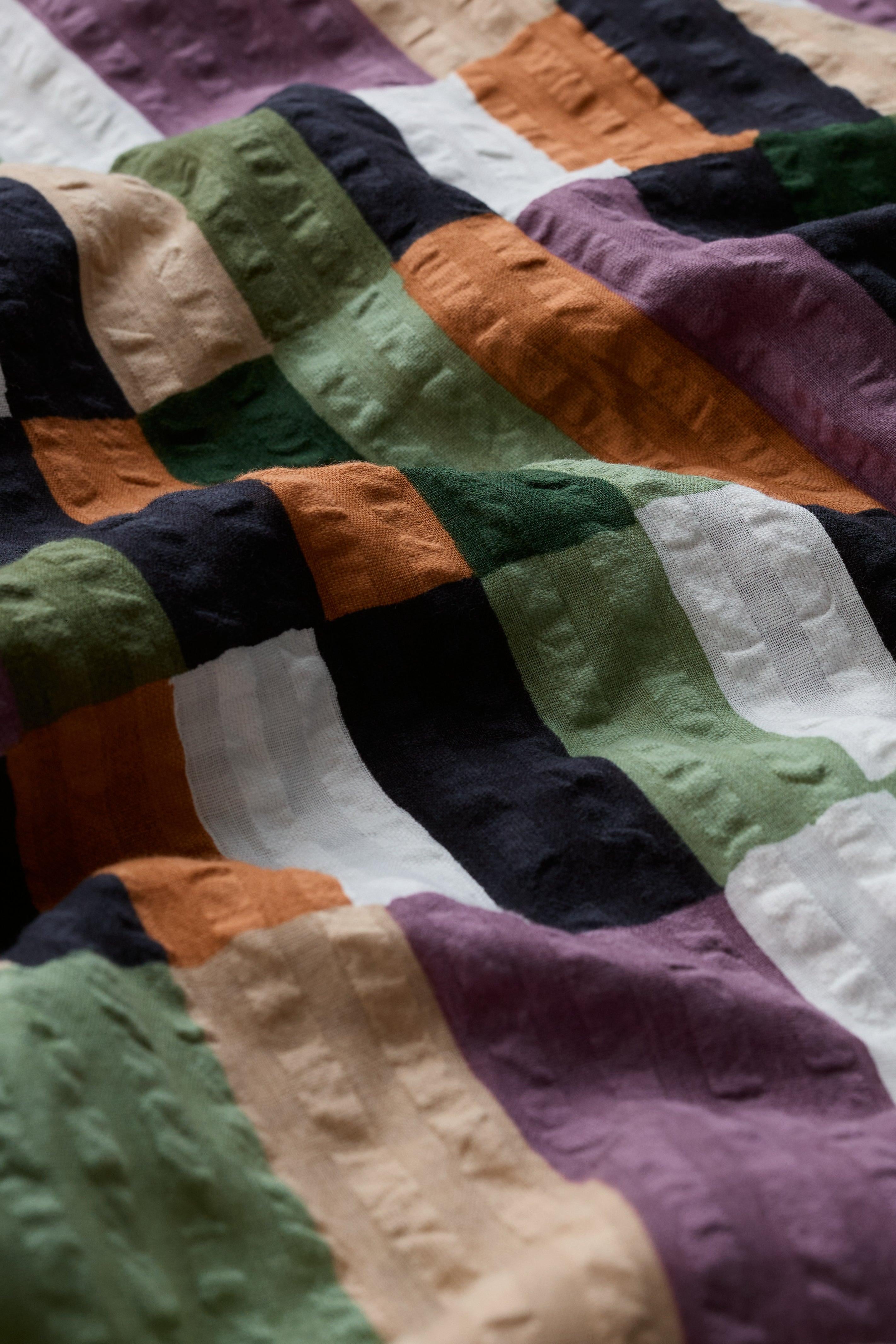 Colourful organic cotton dress with geometric pattern on a soft focus background