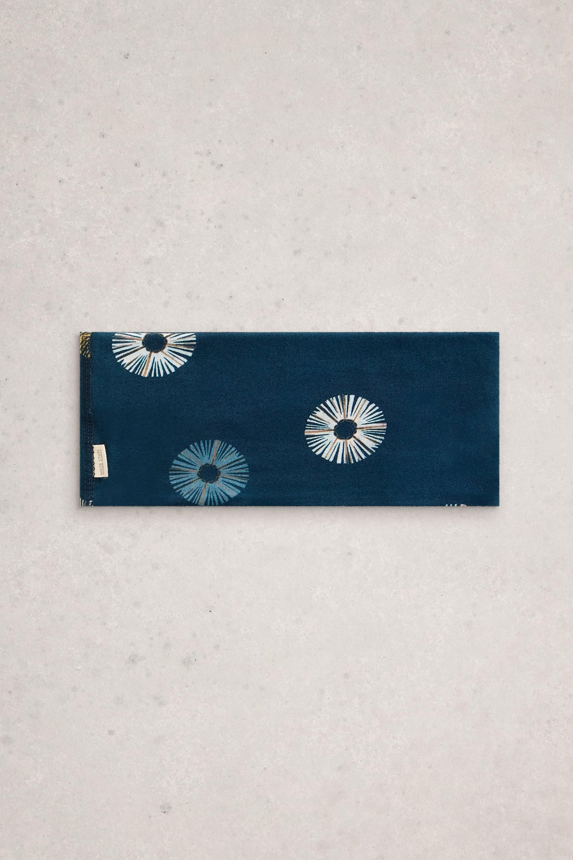Navy headband with white floral patterns on a light gray background