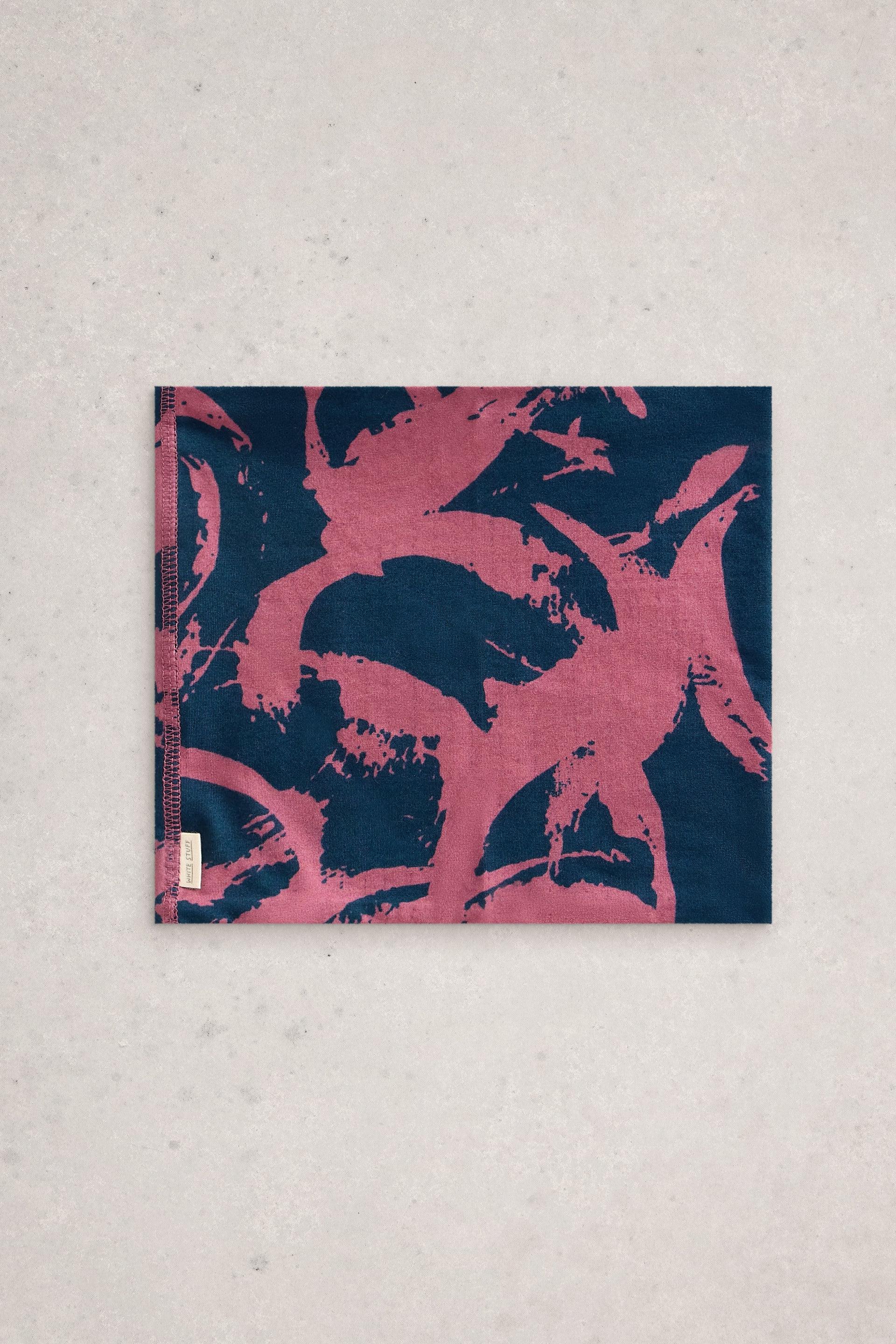 A rectangular neck warmer by White Stuff featuring a dark blue background with abstract pink brushstroke patterns