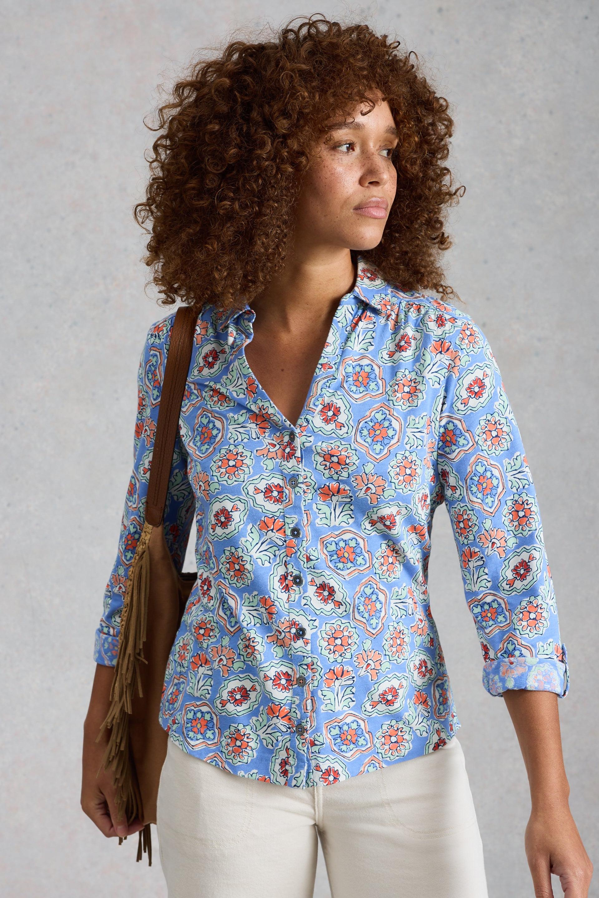 Woman wearing a blue floral blouse with a plain background