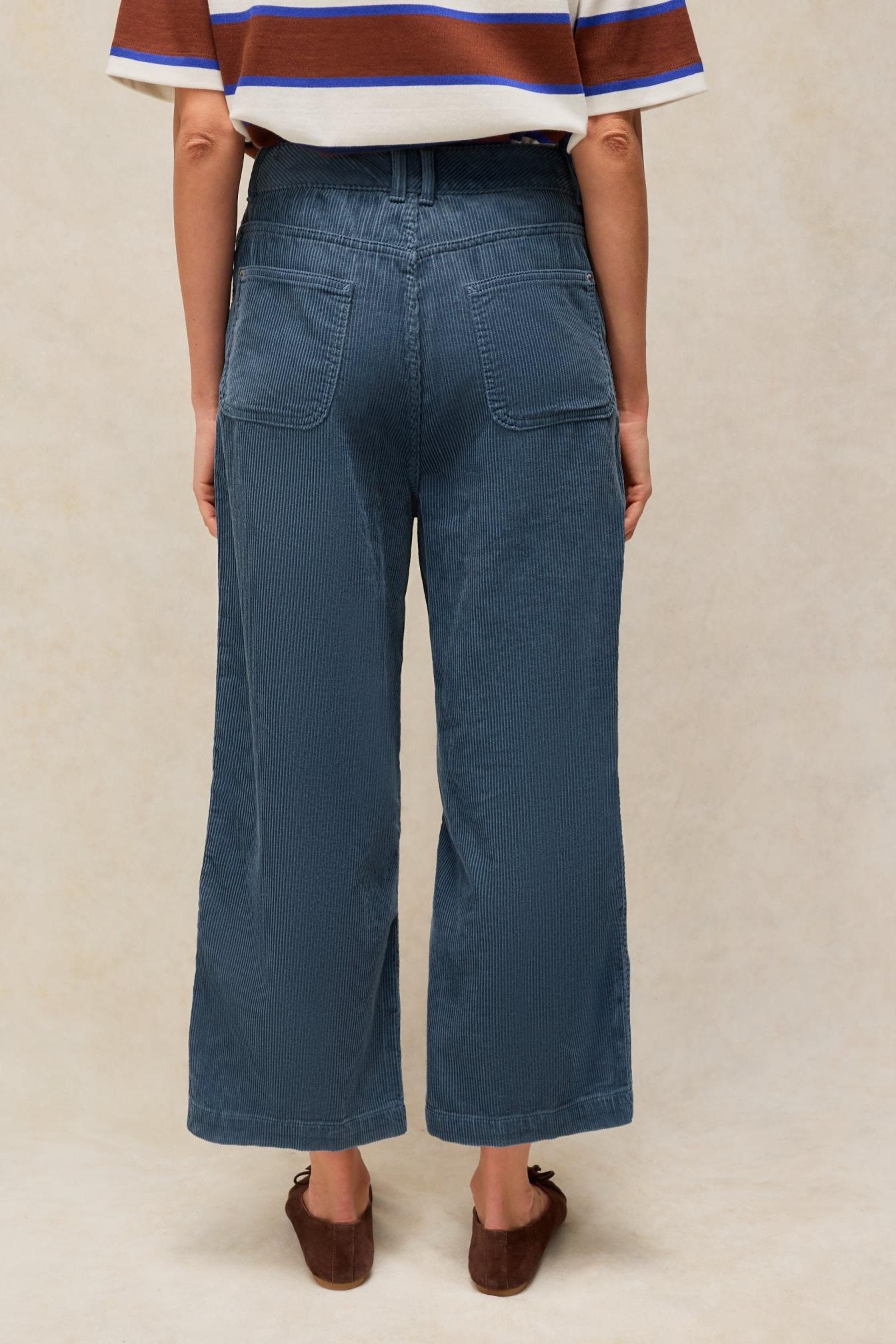 Rear view of a person wearing blue wide leg cord trousers by White Stuff