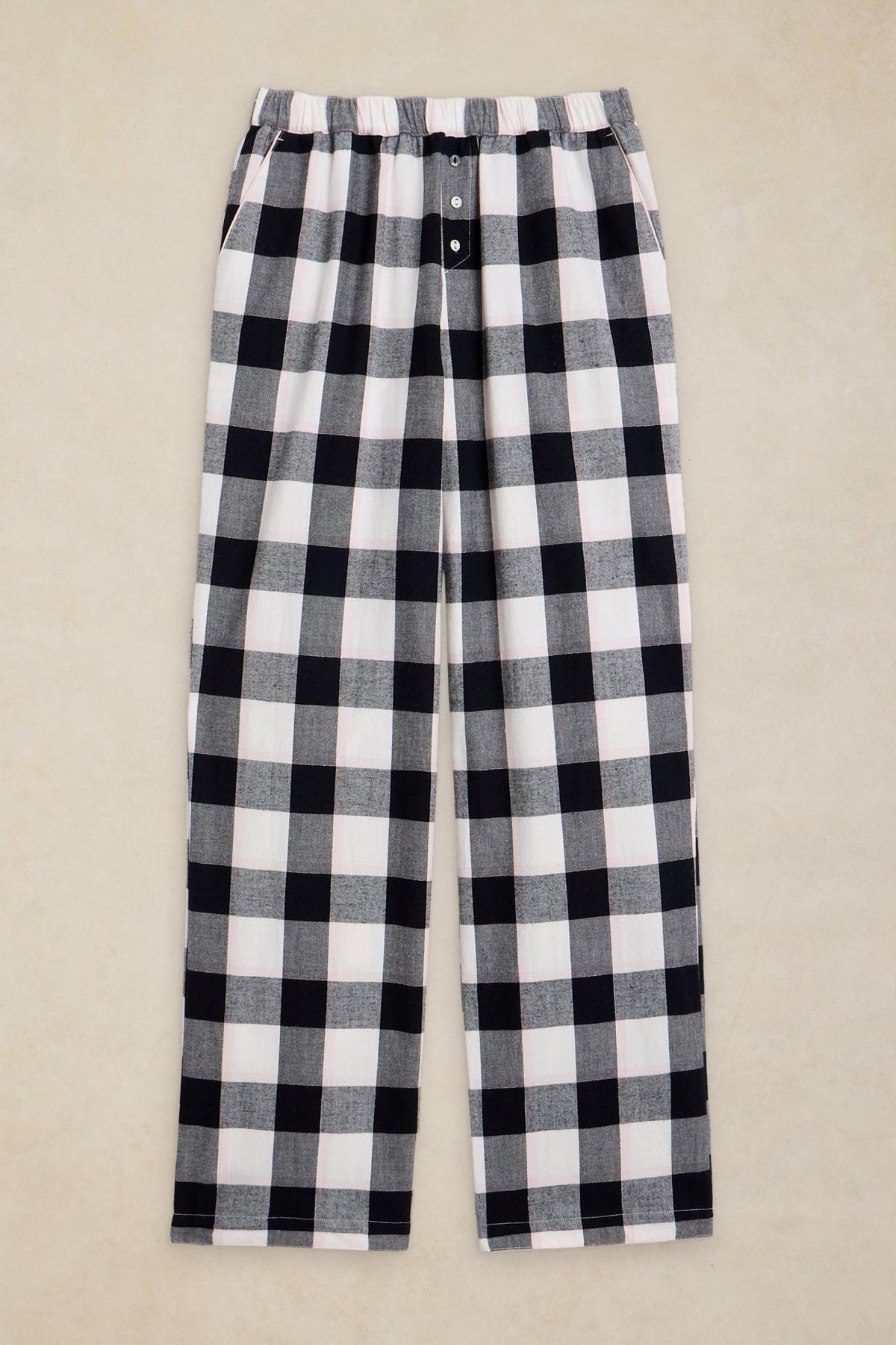 White Stuff organic cotton pyjama bottoms with a black and white check print against a neutral background.