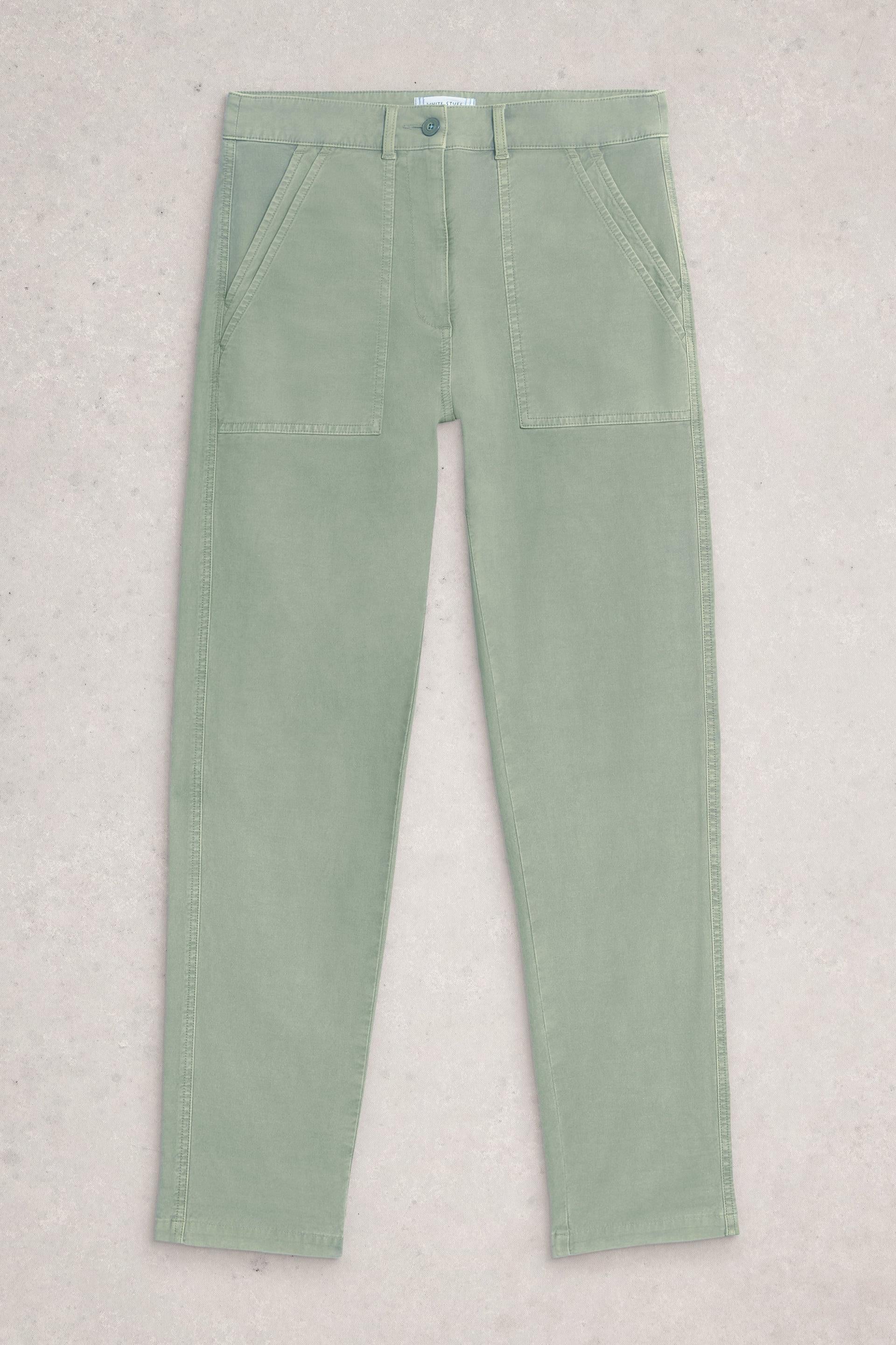 Green White Stuff pants on a light gray background
