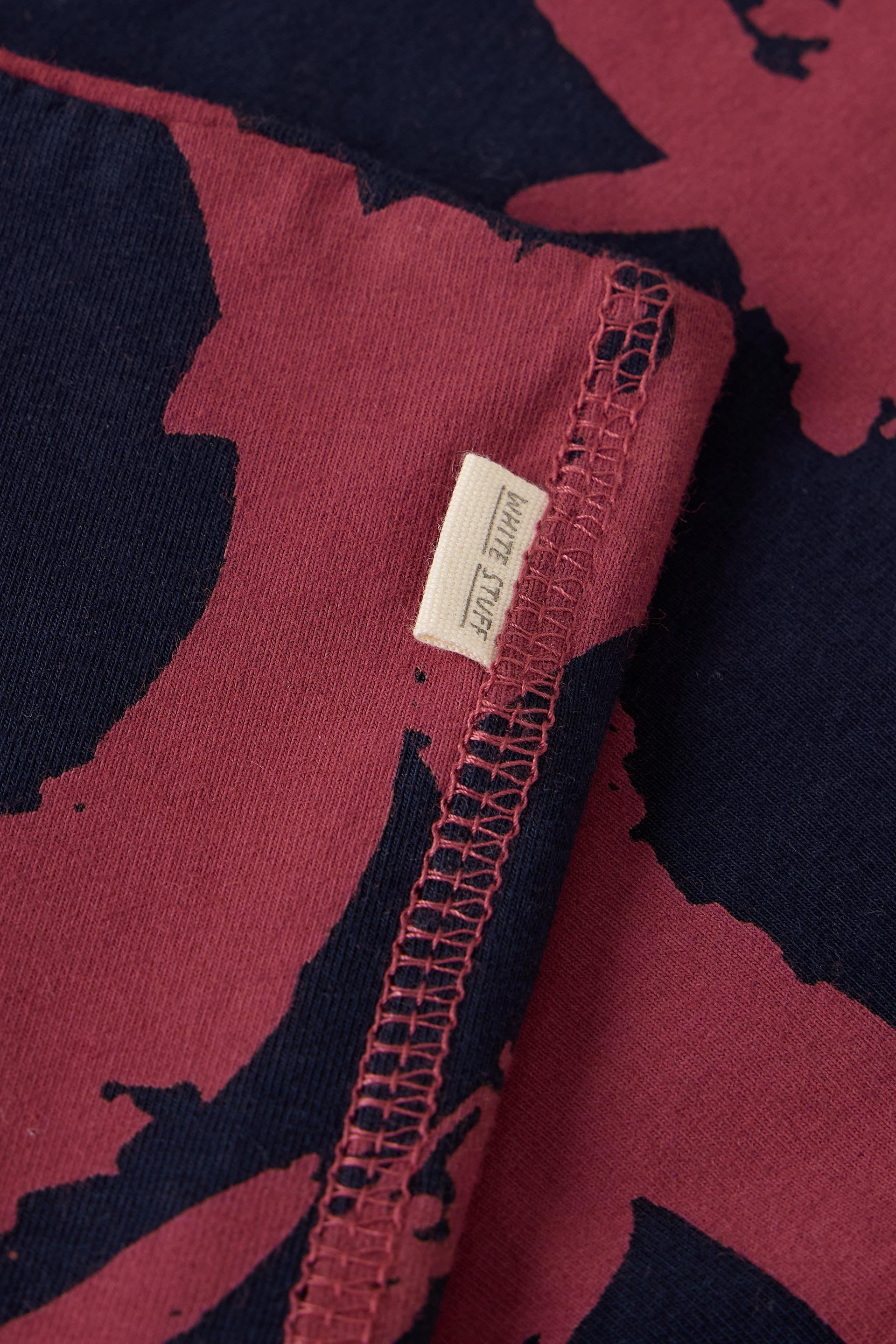 Close-up of fabric featuring a dark blue and maroon abstract pattern with a White Stuff clothing brand label