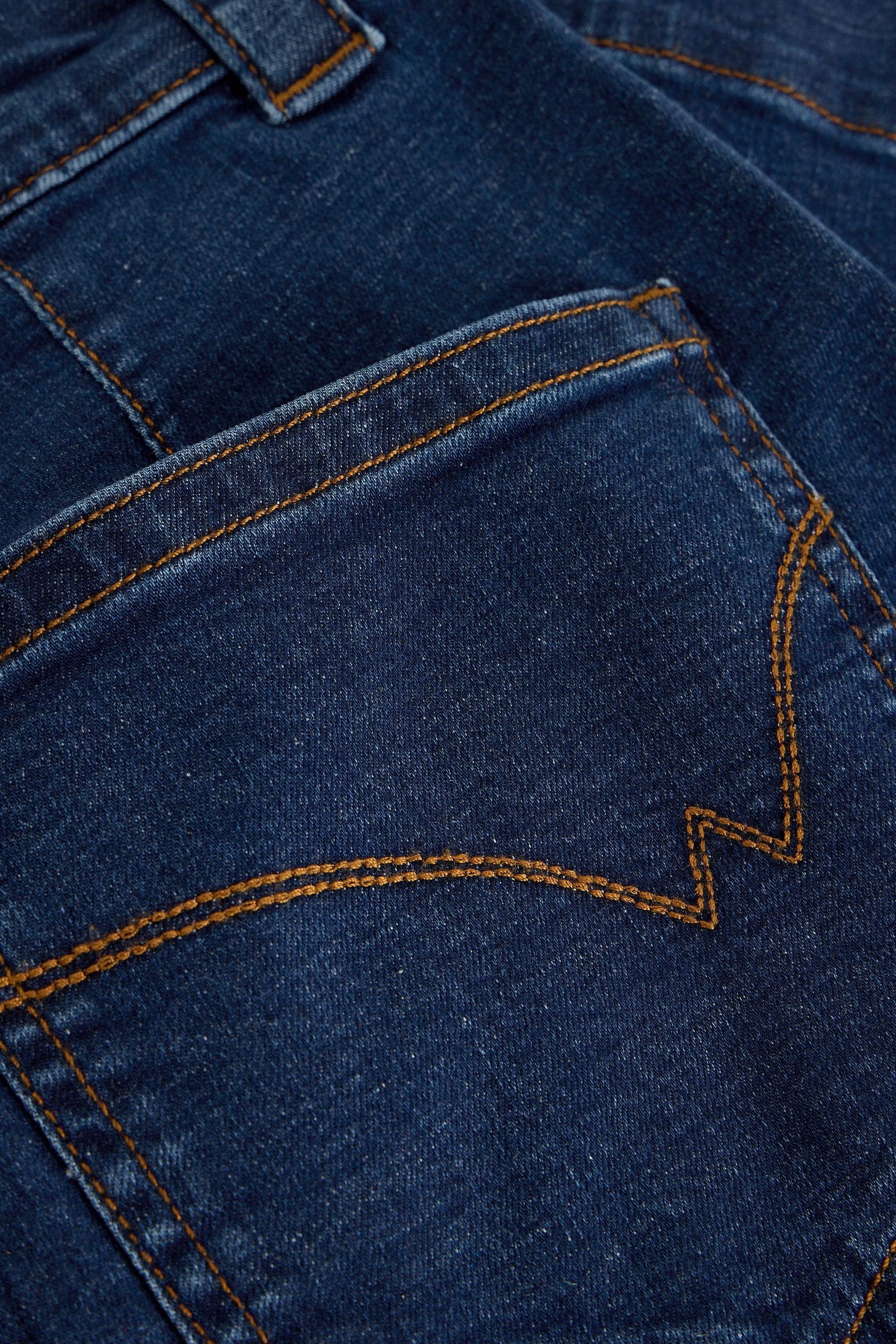 Close-up of blue denim fabric with stitching details