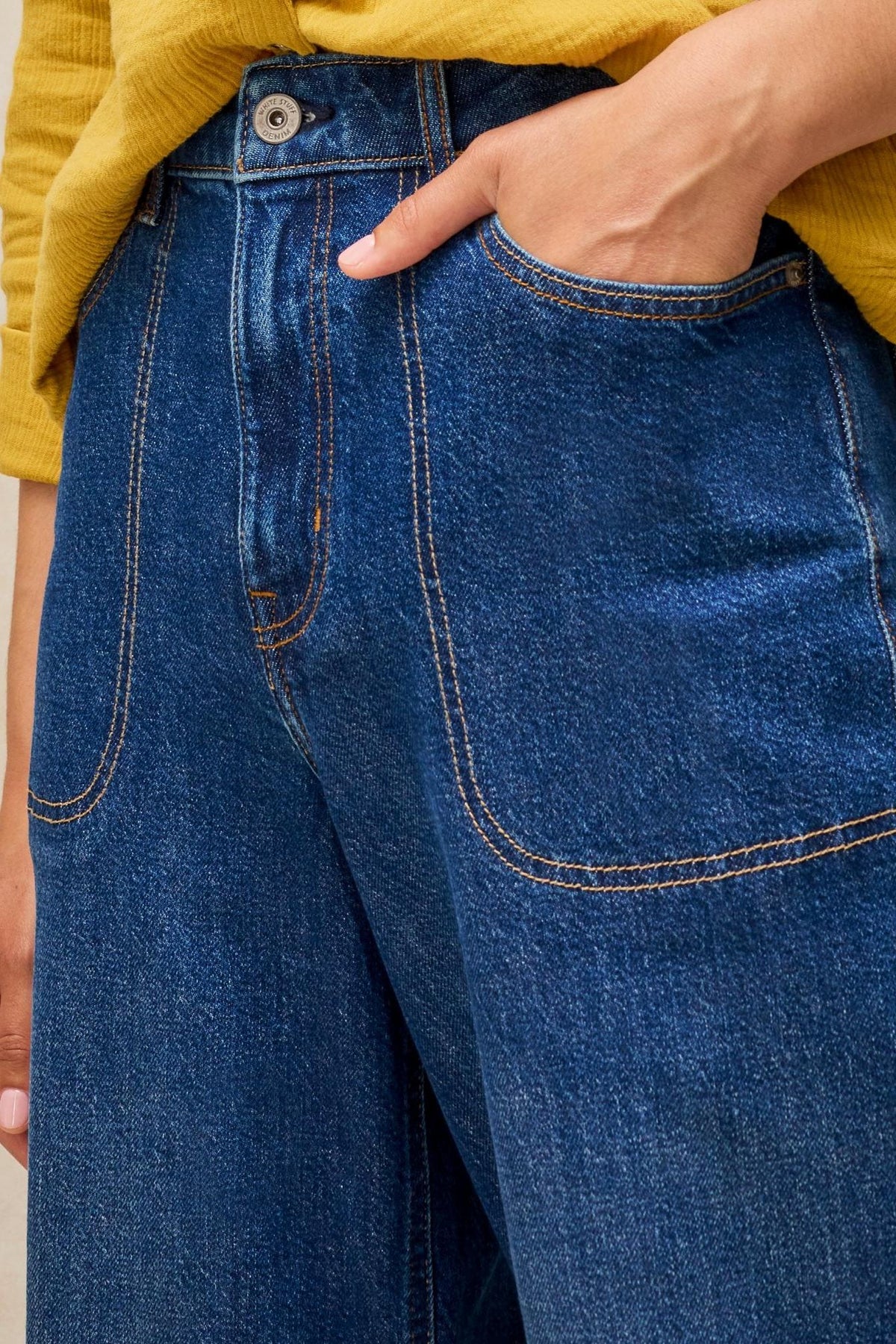 Close-up of White Stuff dark denim wide leg jeans with visible pocket stitching.