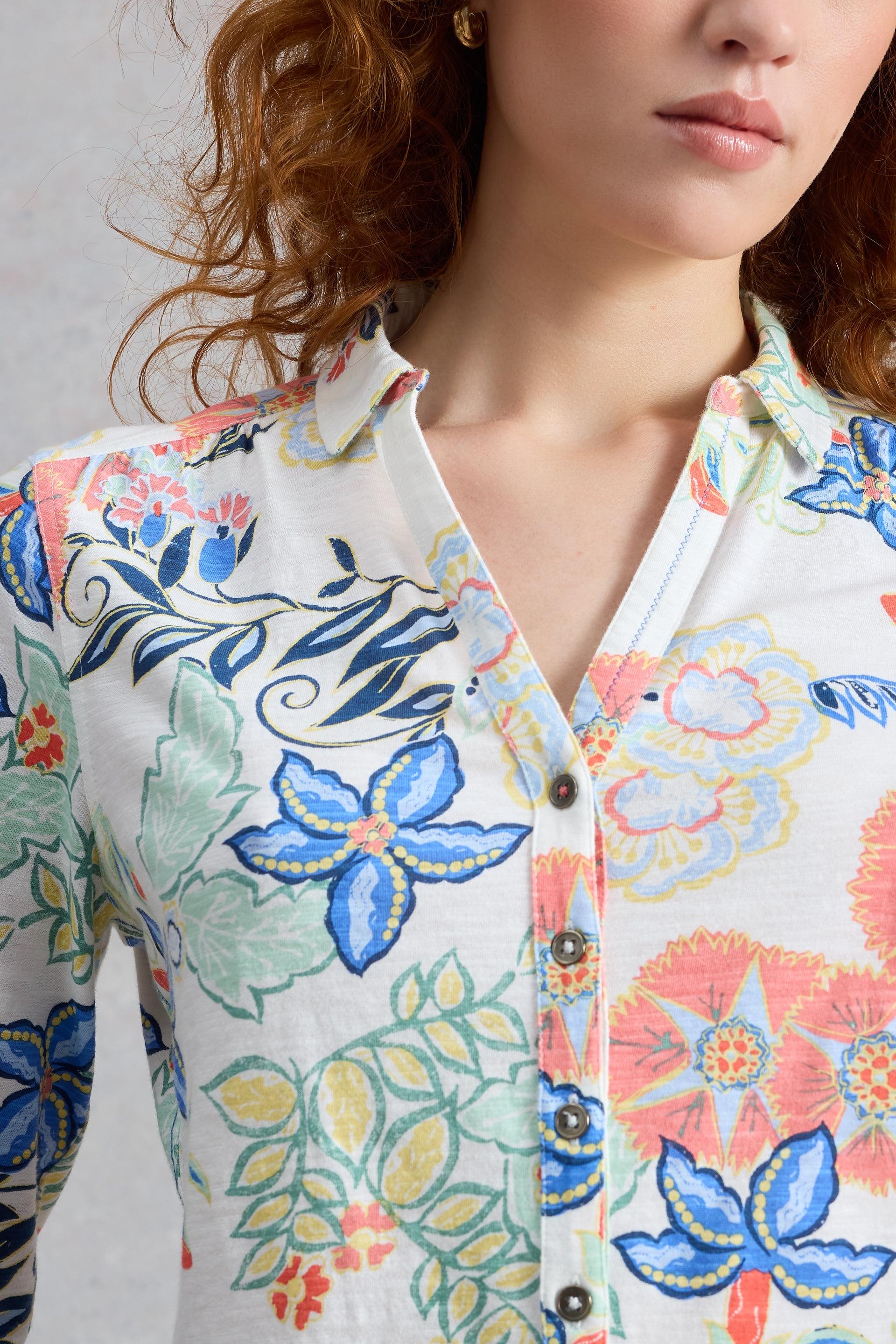 Close-up of a model wearing a colourful floral shirt against a neutral background