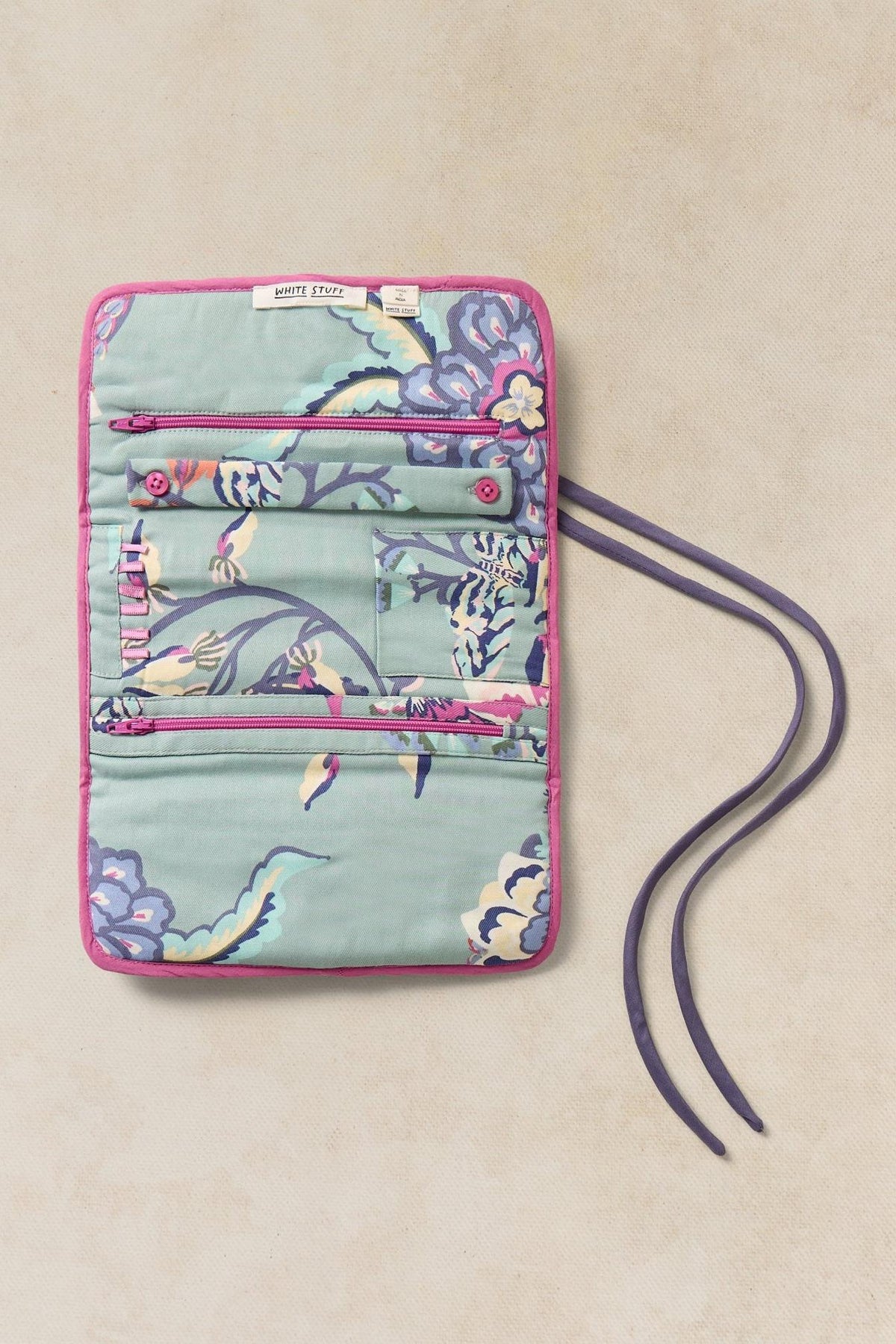 Open White Stuff travel jewellery organiser in a teal floral print with pink trim on a neutral background.