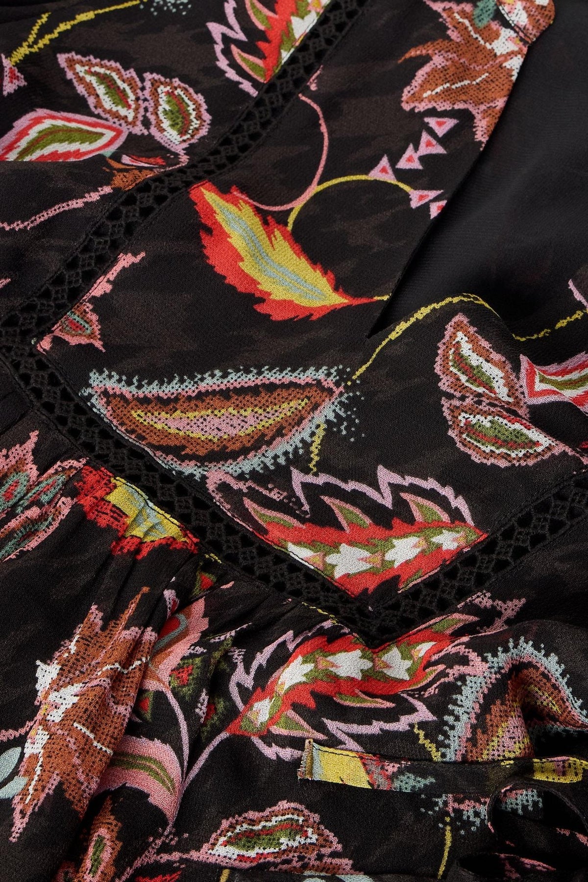Close-up of a black White Stuff viscose shirt featuring a vibrant multi-colored floral embroidery and lace trim detail.