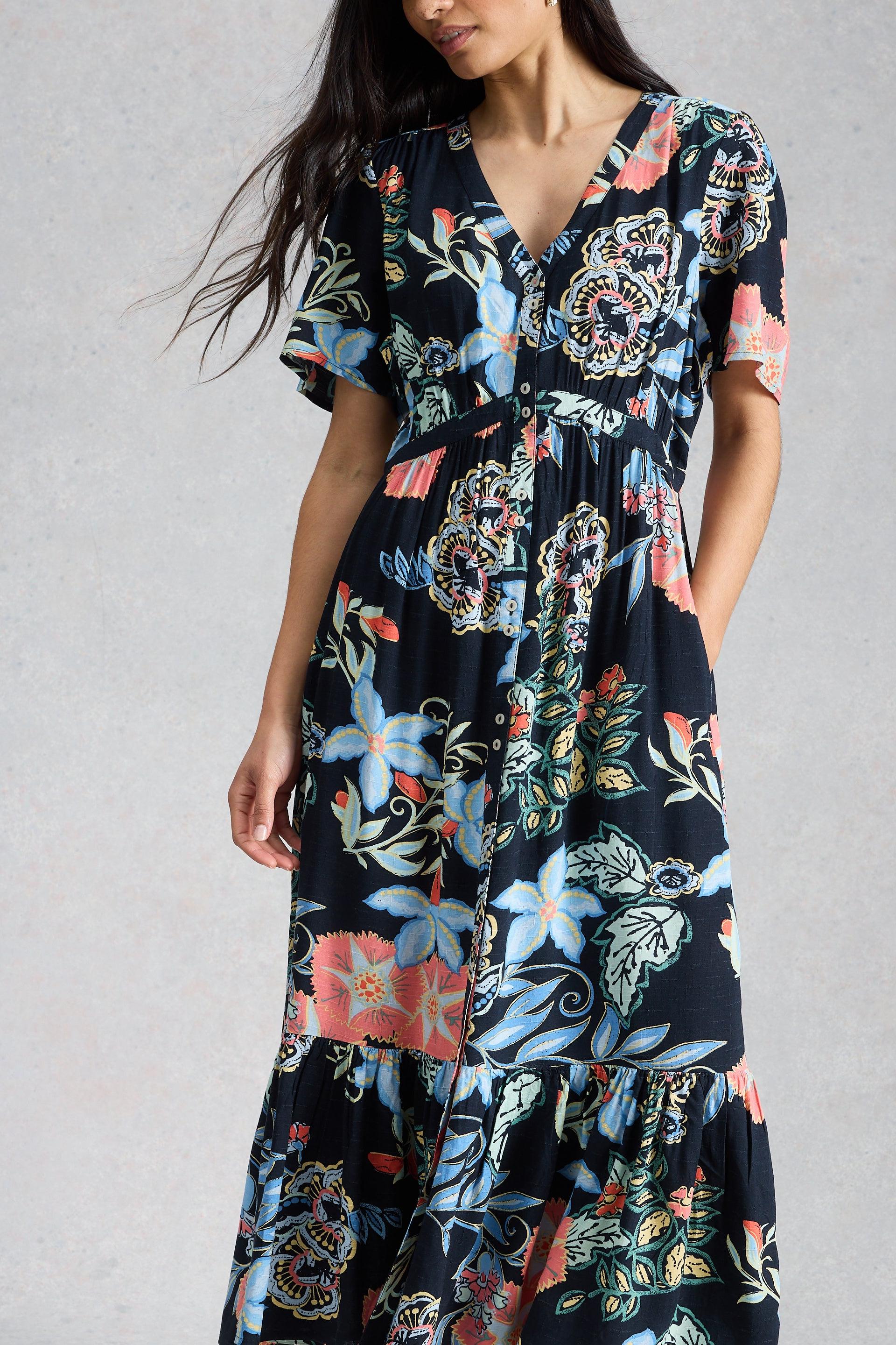 Woman wearing a floral midi dress with a neutral background