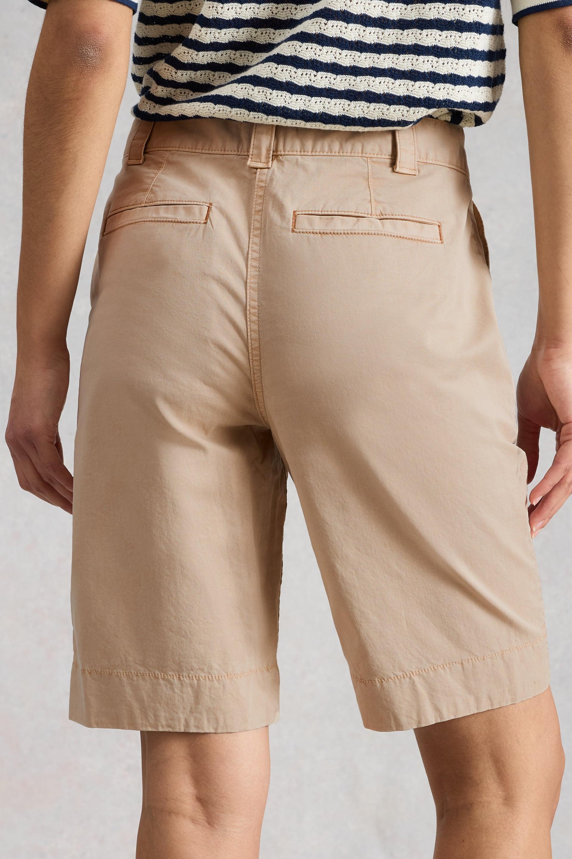 Beige organic cotton shorts worn by a person on a plain background