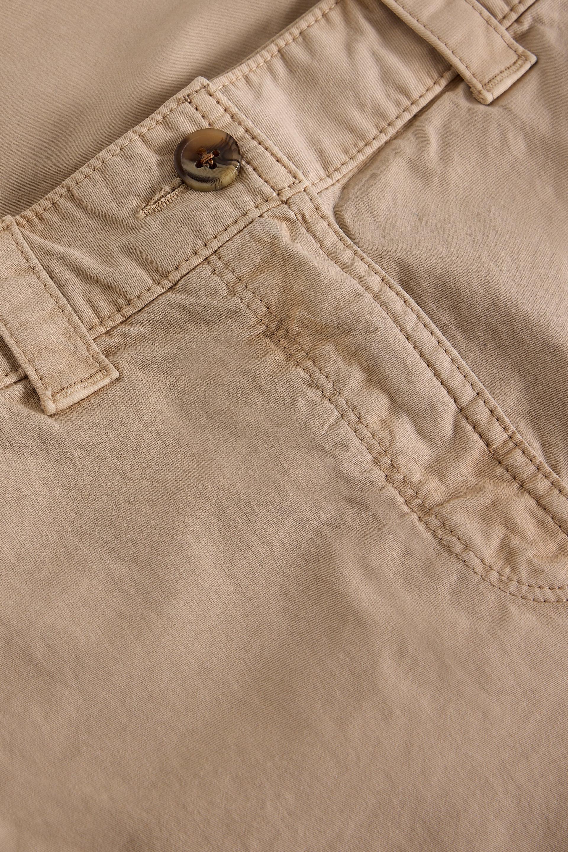 Close-up of beige organic cotton shorts with a button and stitching detail
