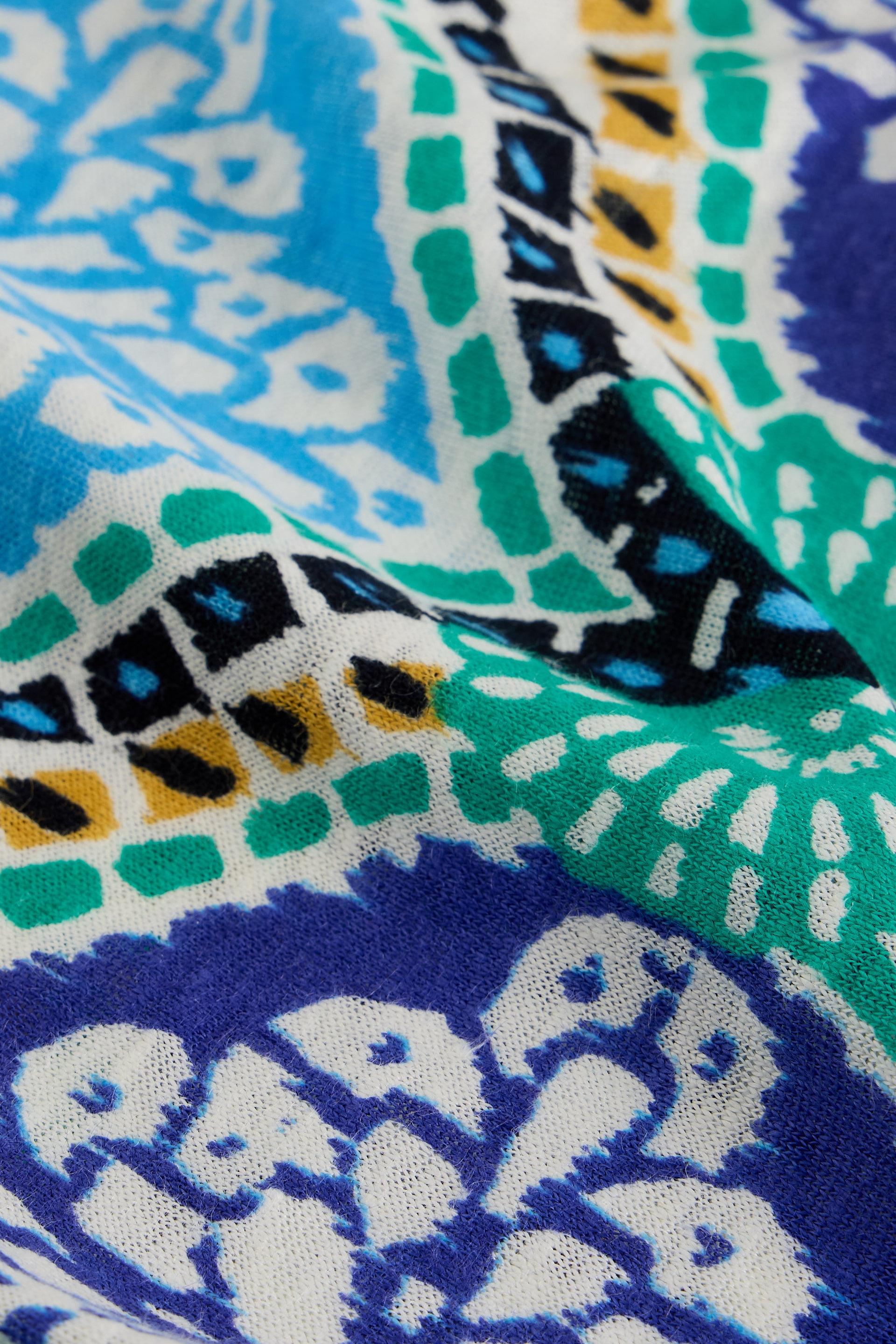 Close-up of patterned fabric with blue, green, and white colors.