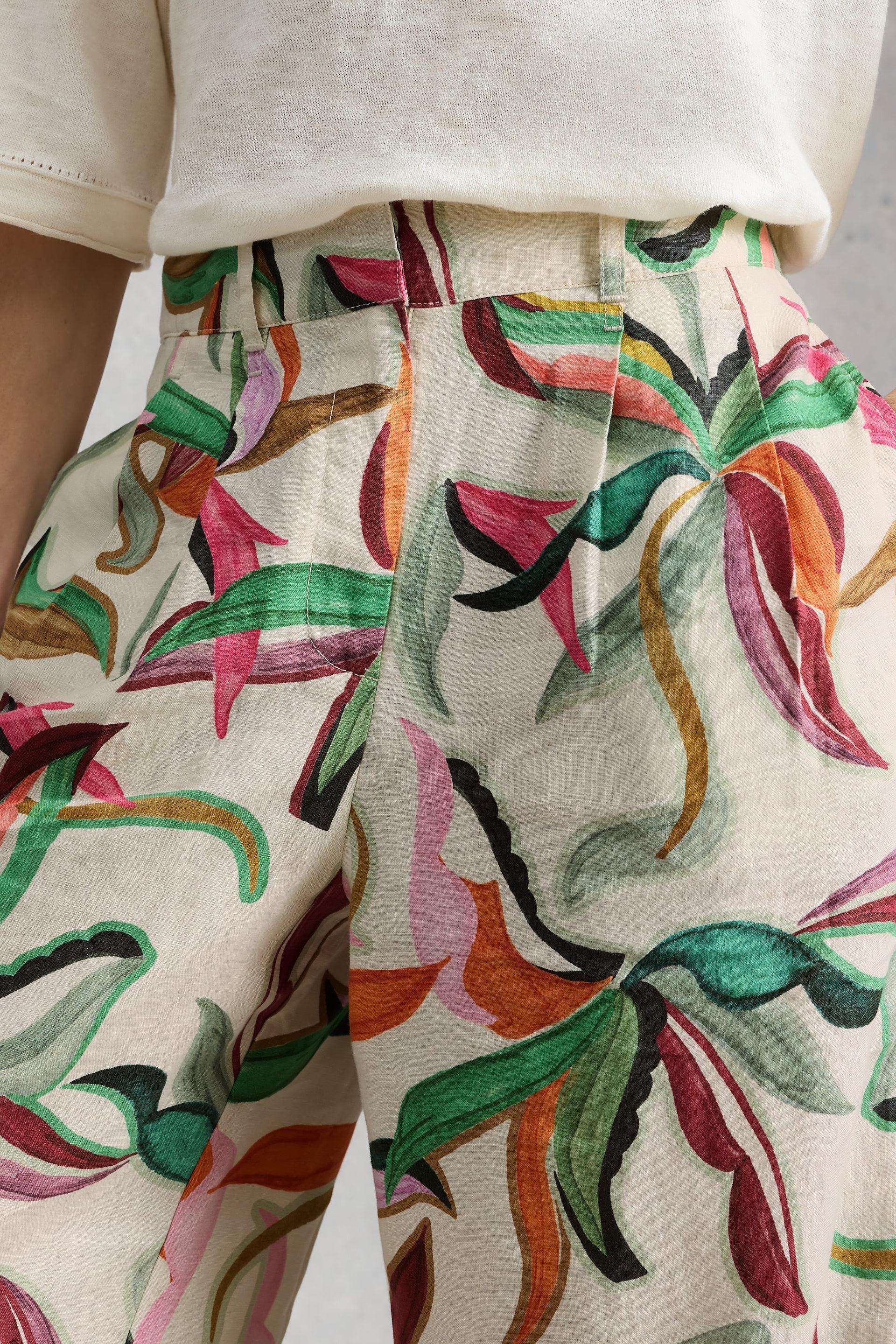 Colourful floral linen trousers on a white background