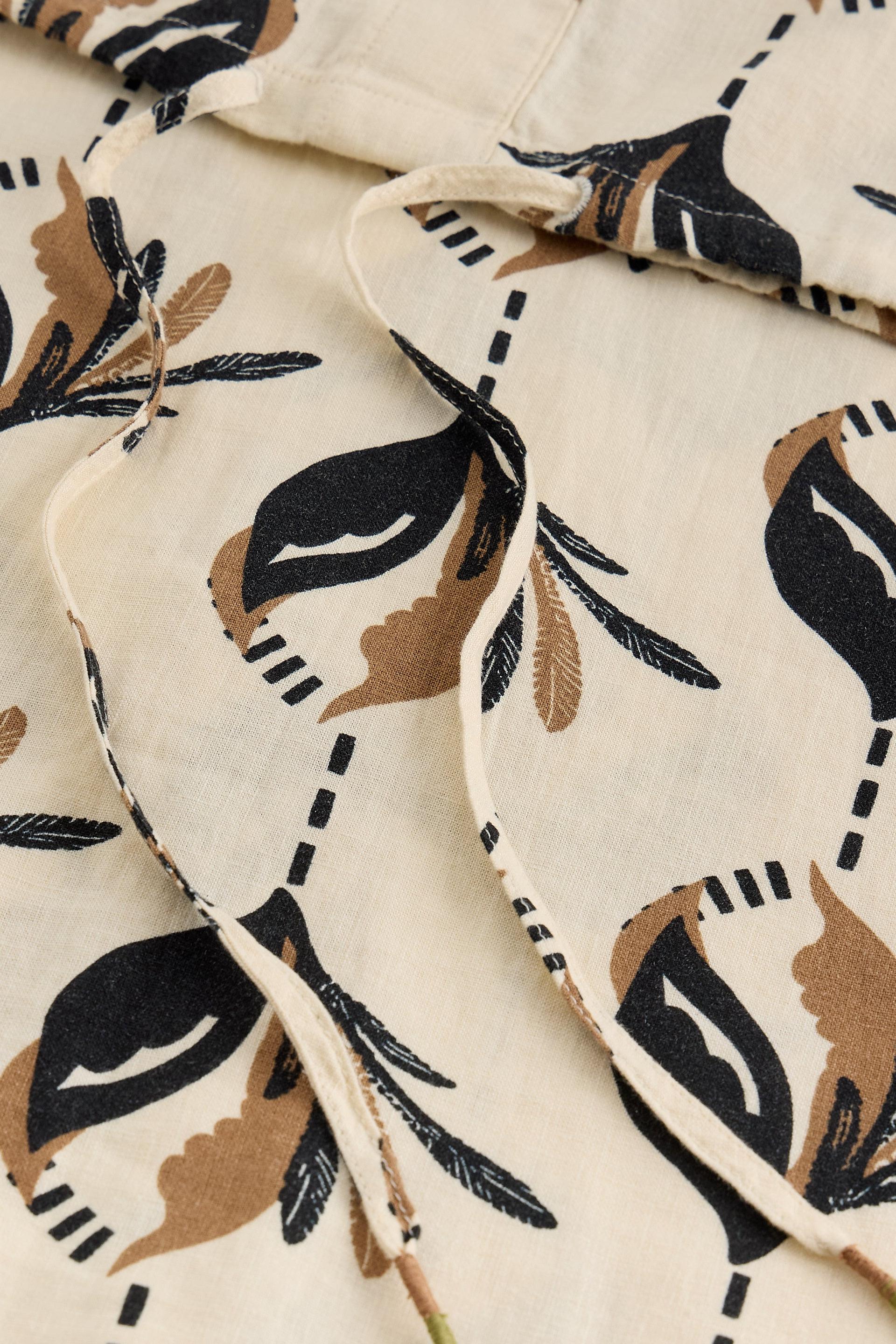 Close-up of a beige linen top with black and brown floral pattern