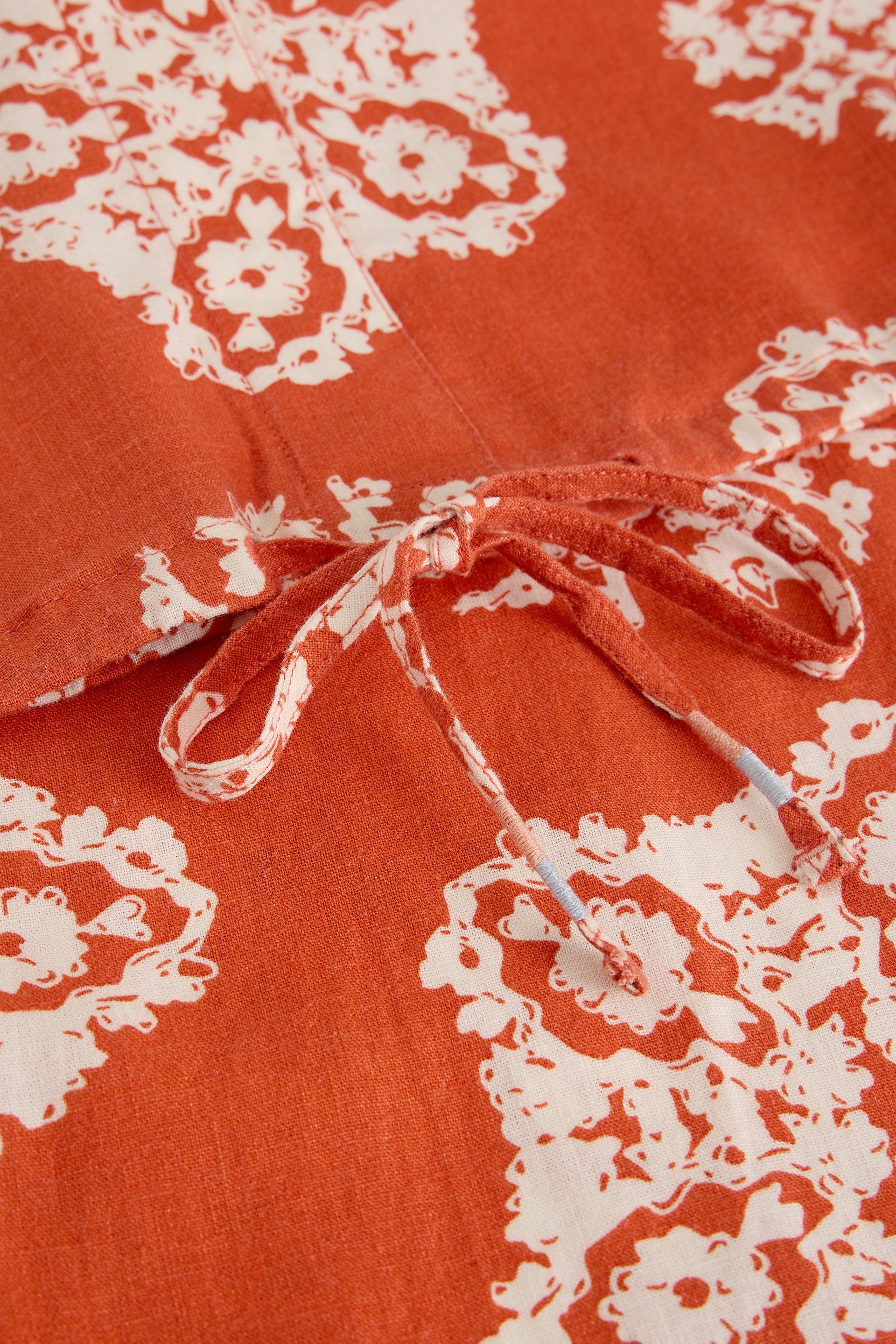Close up of drawstring hem on red linen top 