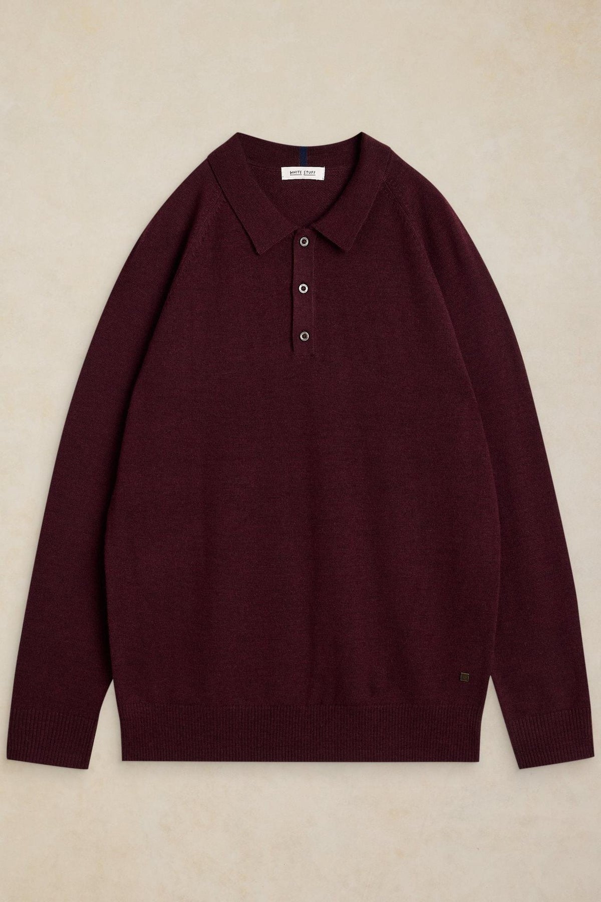 White Stuff men's long-sleeve polo shirt in plum-coloured merino wool against a neutral background.