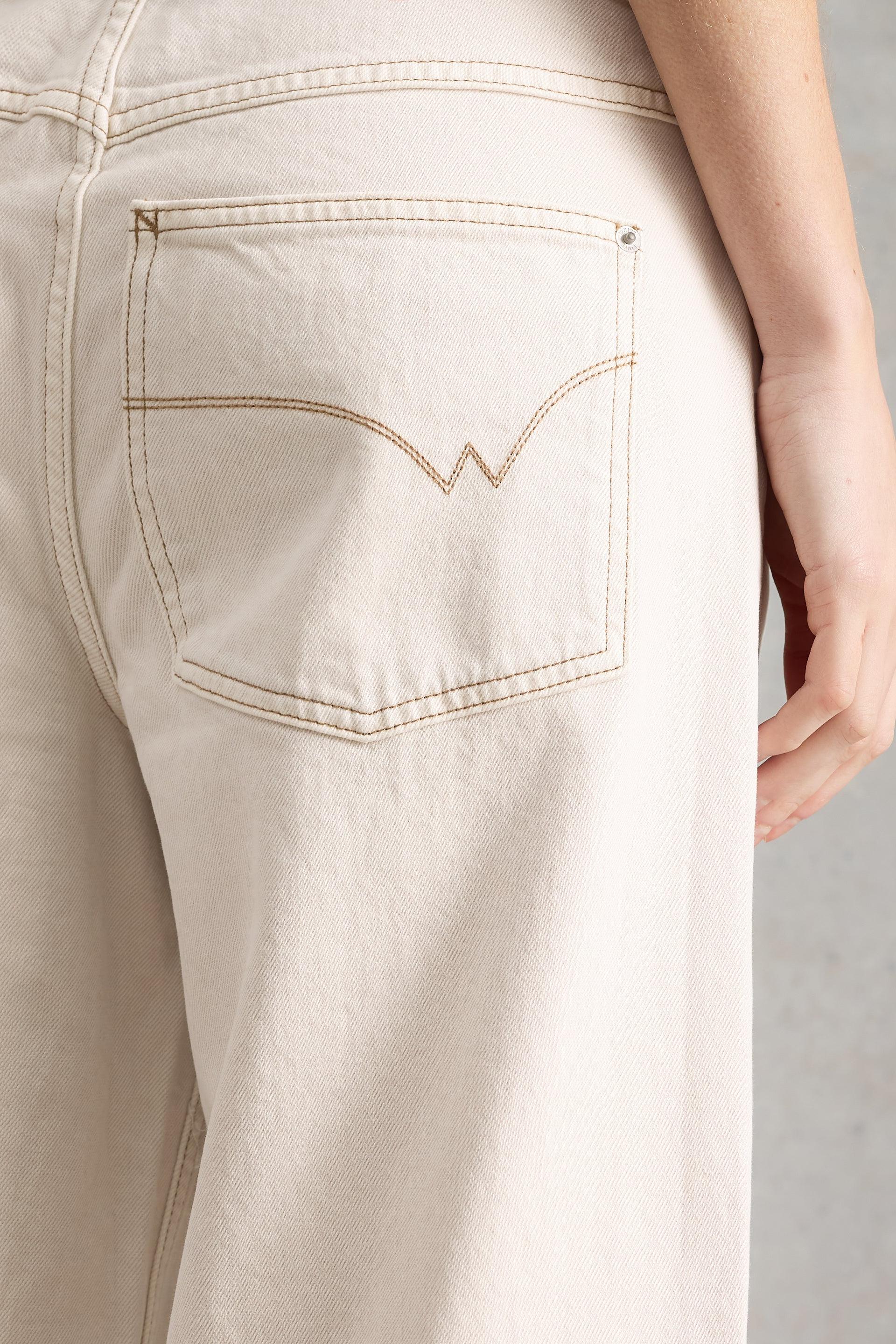 Close-up of the back pocket and stitching detail on White Stuff organic cotton cream jeans.