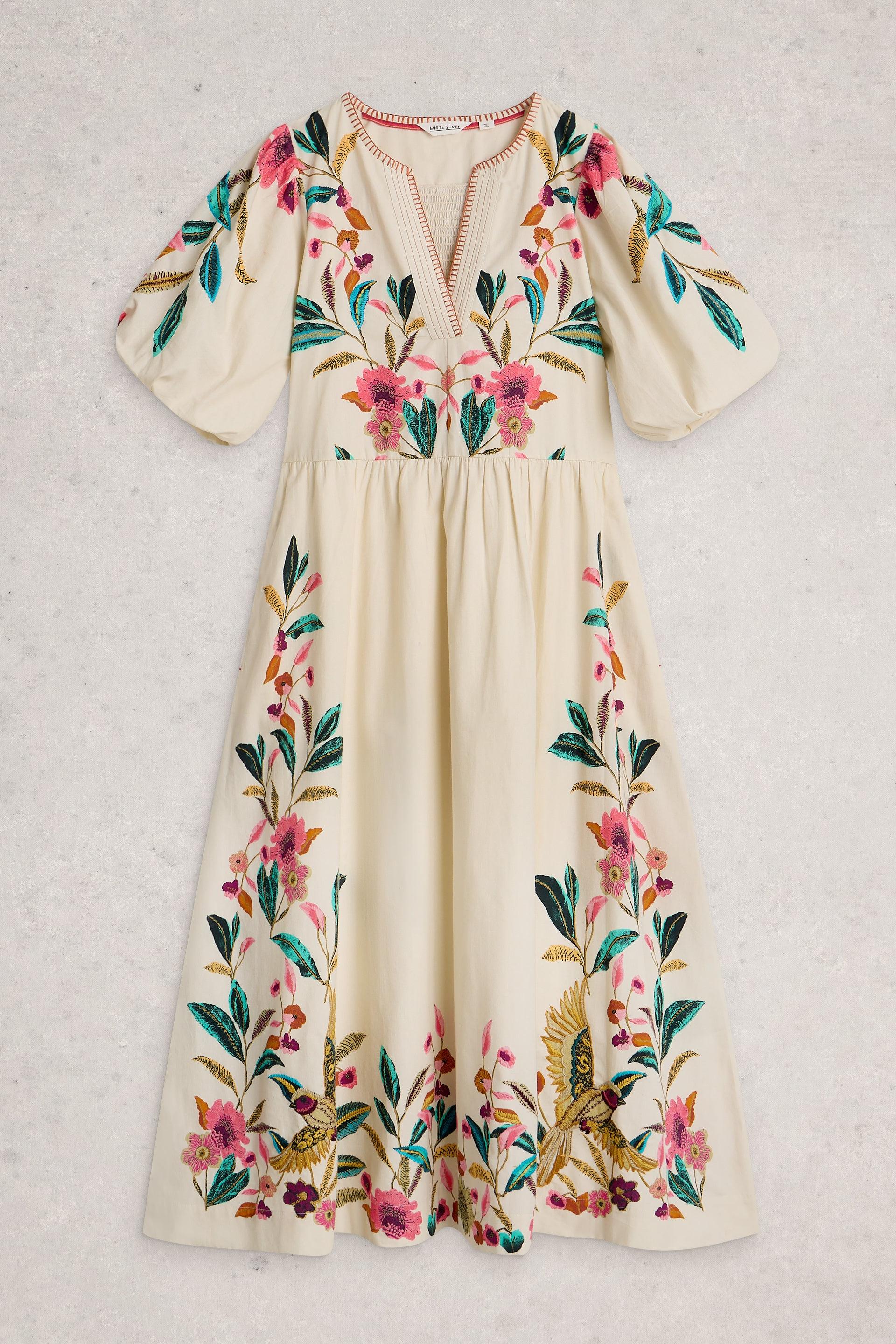 Cream-colored organic cotton midi occasion dress with vibrant floral embroidery and puff sleeves.