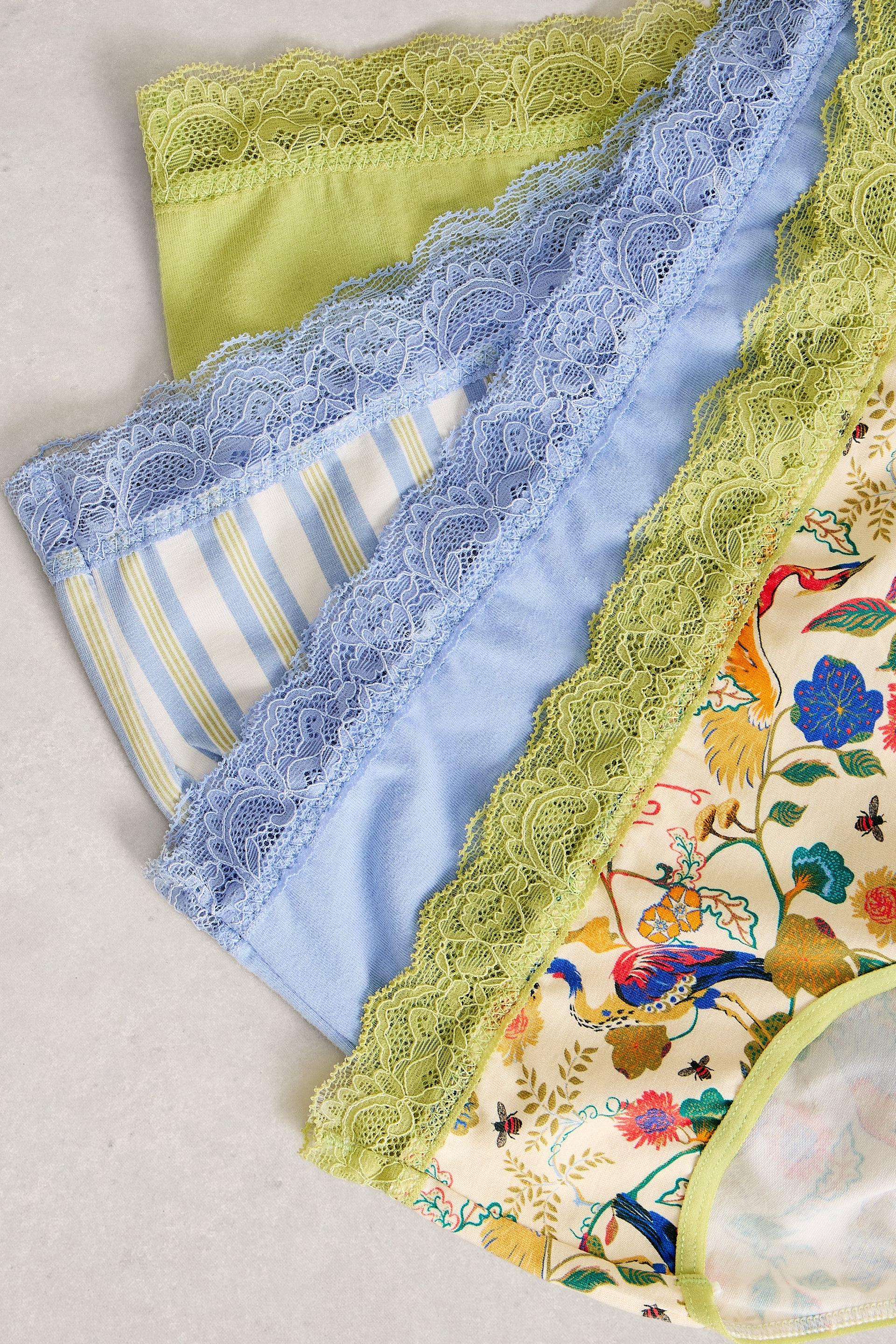 A selection of colourful organic cotton lace-trim briefs from White Stuff arranged on a light surface.