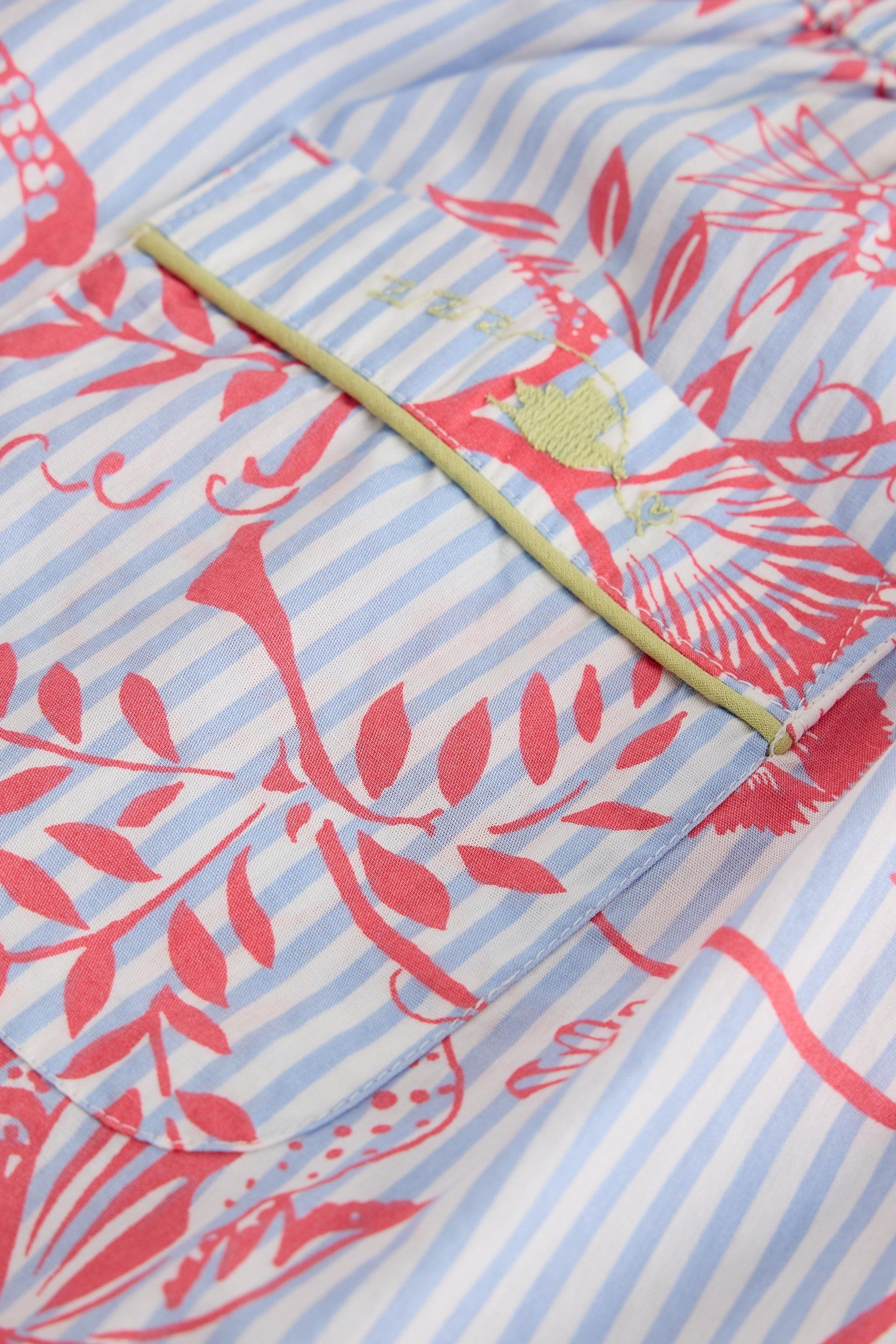 Close-up of a White Stuff organic cotton garment featuring blue striped fabric with a red floral print and a pocket.