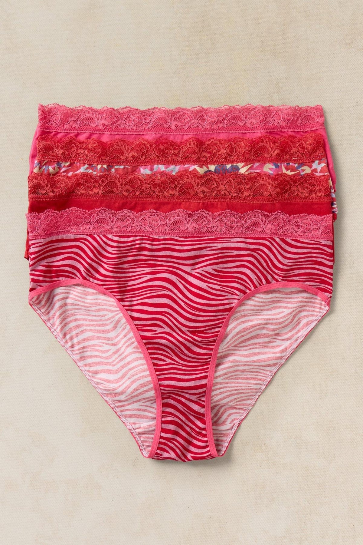 A multi pack of White Stuff organic cotton women's underwear featuring pink and red patterns with lace trim.