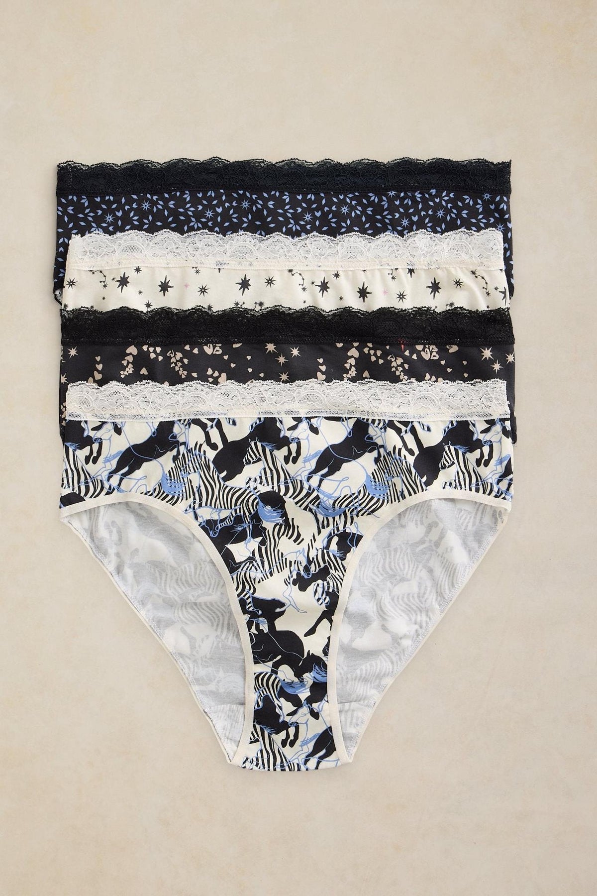 Stack of three pairs of patterned White Stuff organic cotton women's underwear with lace trim.