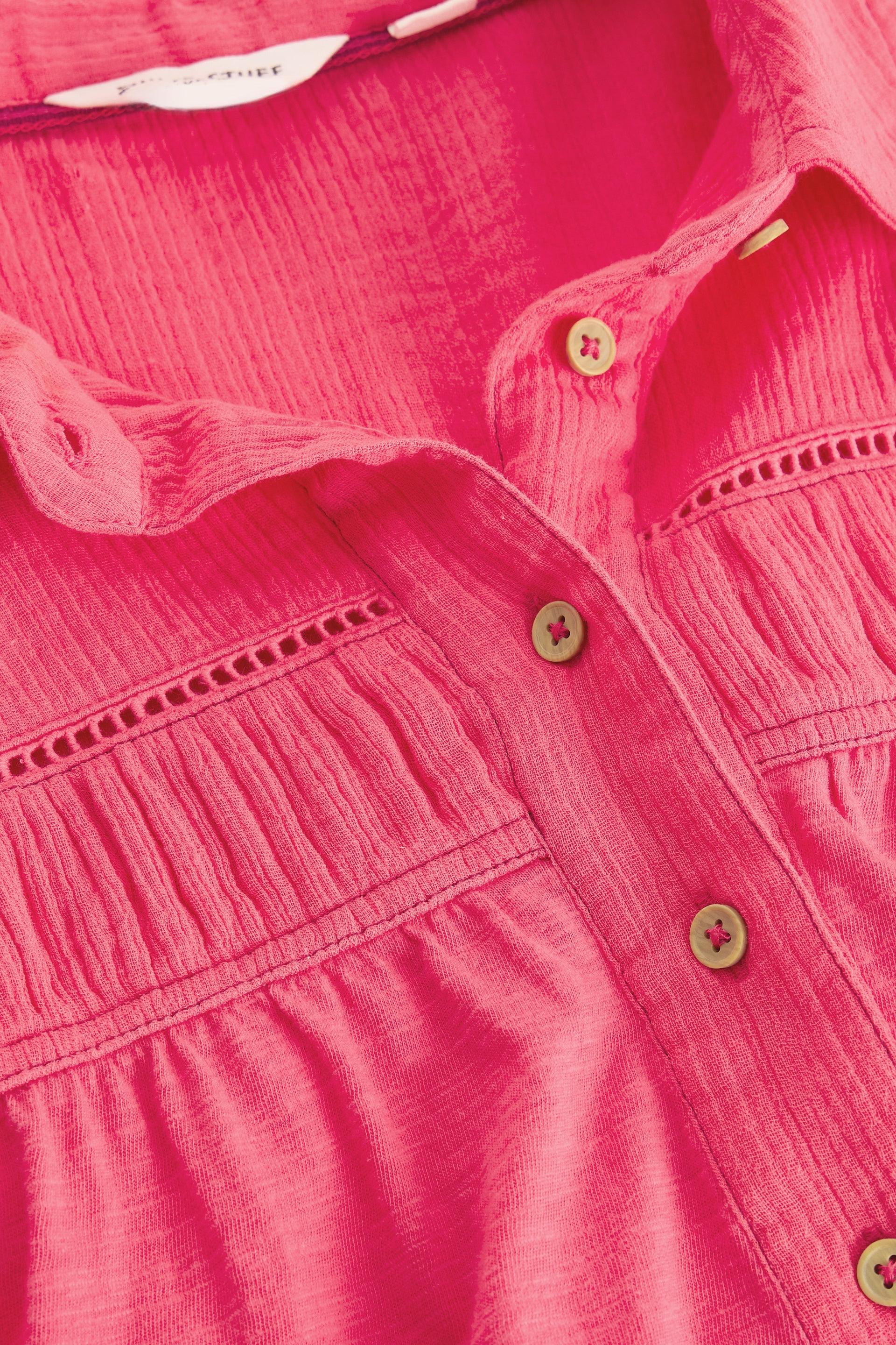 Close-up of a pink White Stuff organic cotton blouse showing the button-down placket and textured fabric.