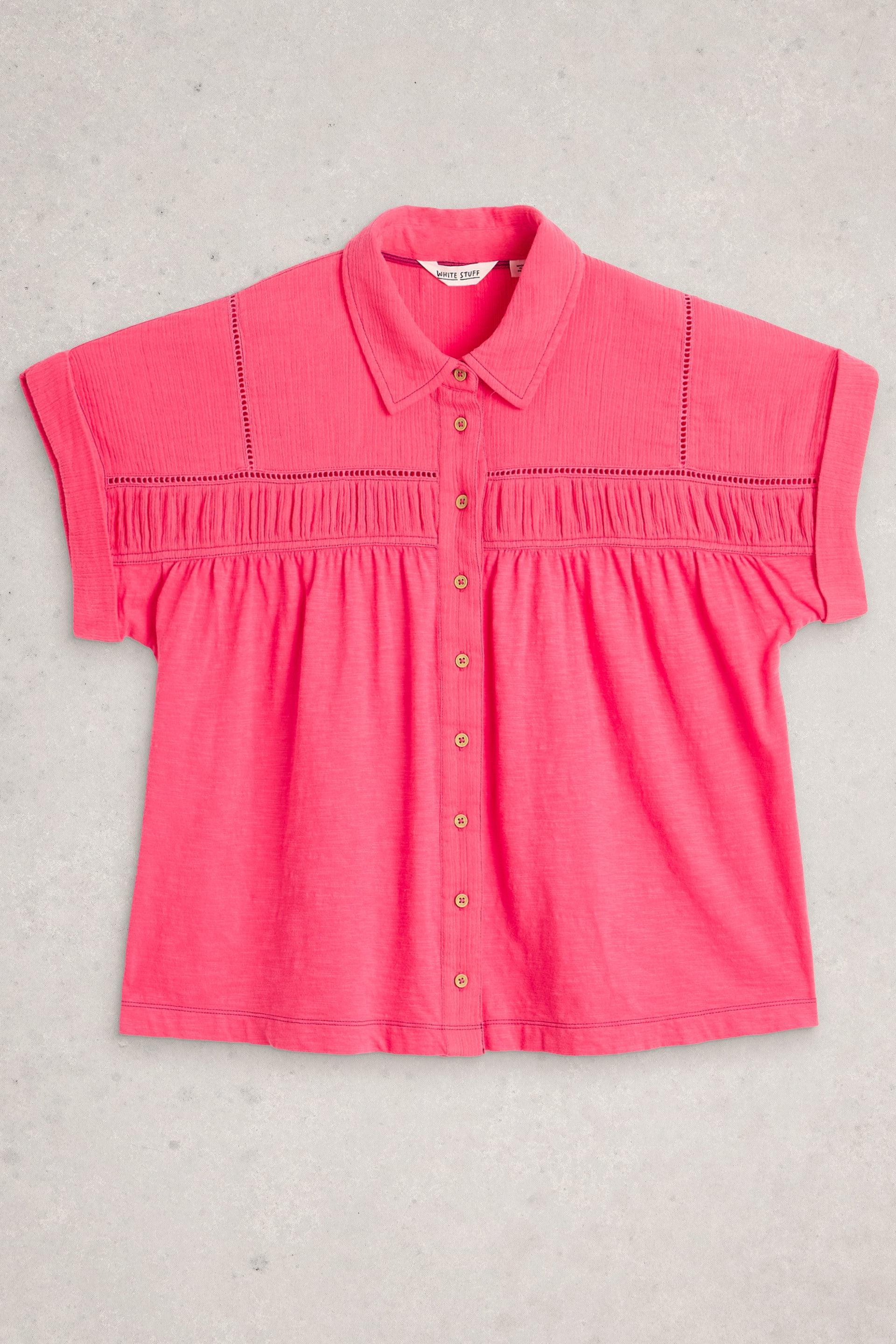 A bright pink White Stuff organic cotton blouse featuring button-down detail and cuffed short sleeves.