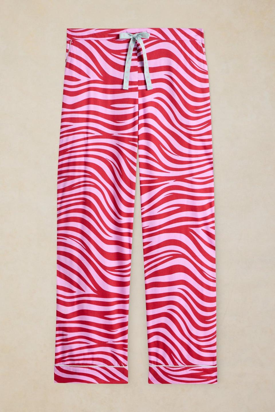Organic cotton pyjama bottoms with a pink and red zebra print pattern and a drawstring waist.